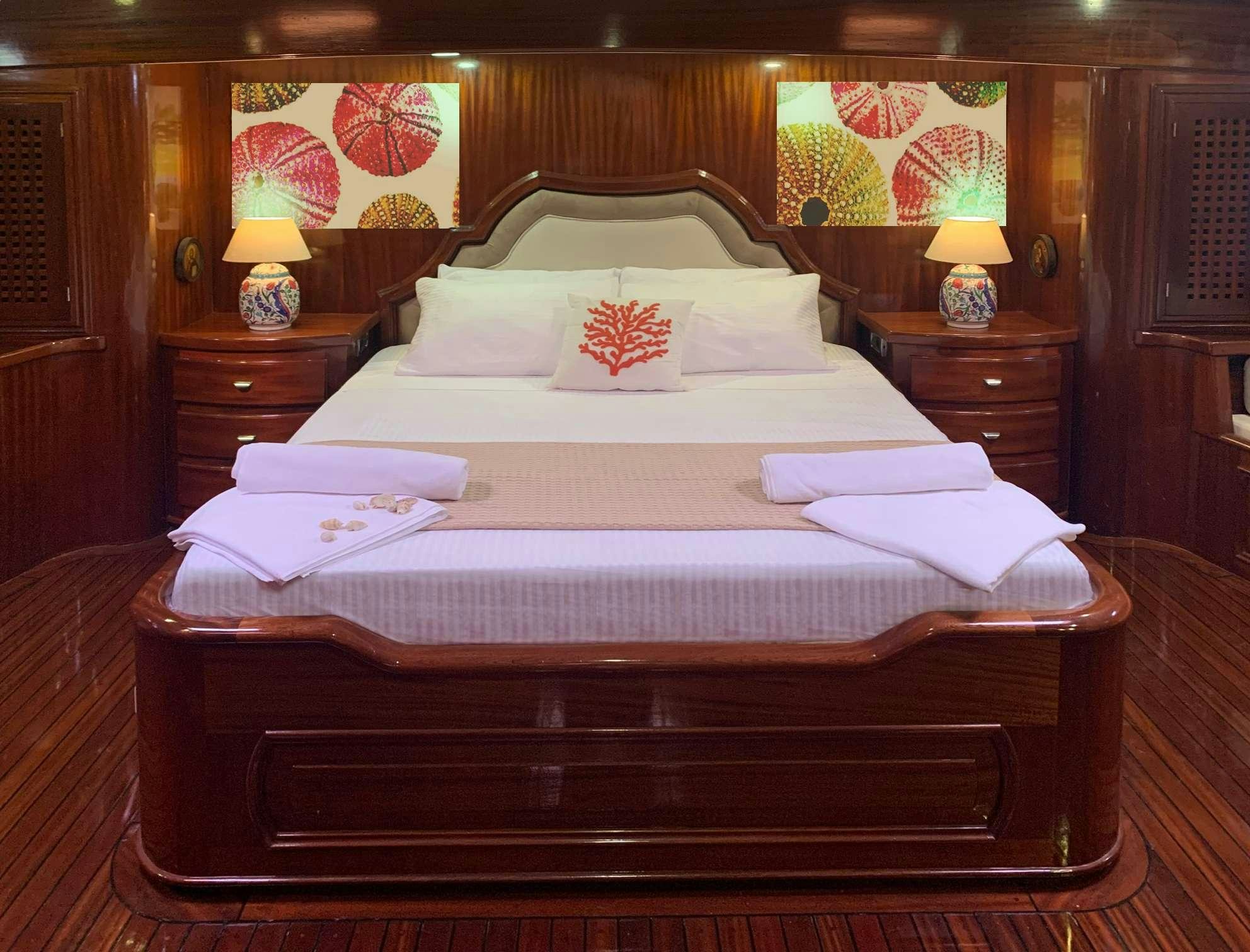 a bed with a white comforter aboard ELIANORA Yacht for Charter