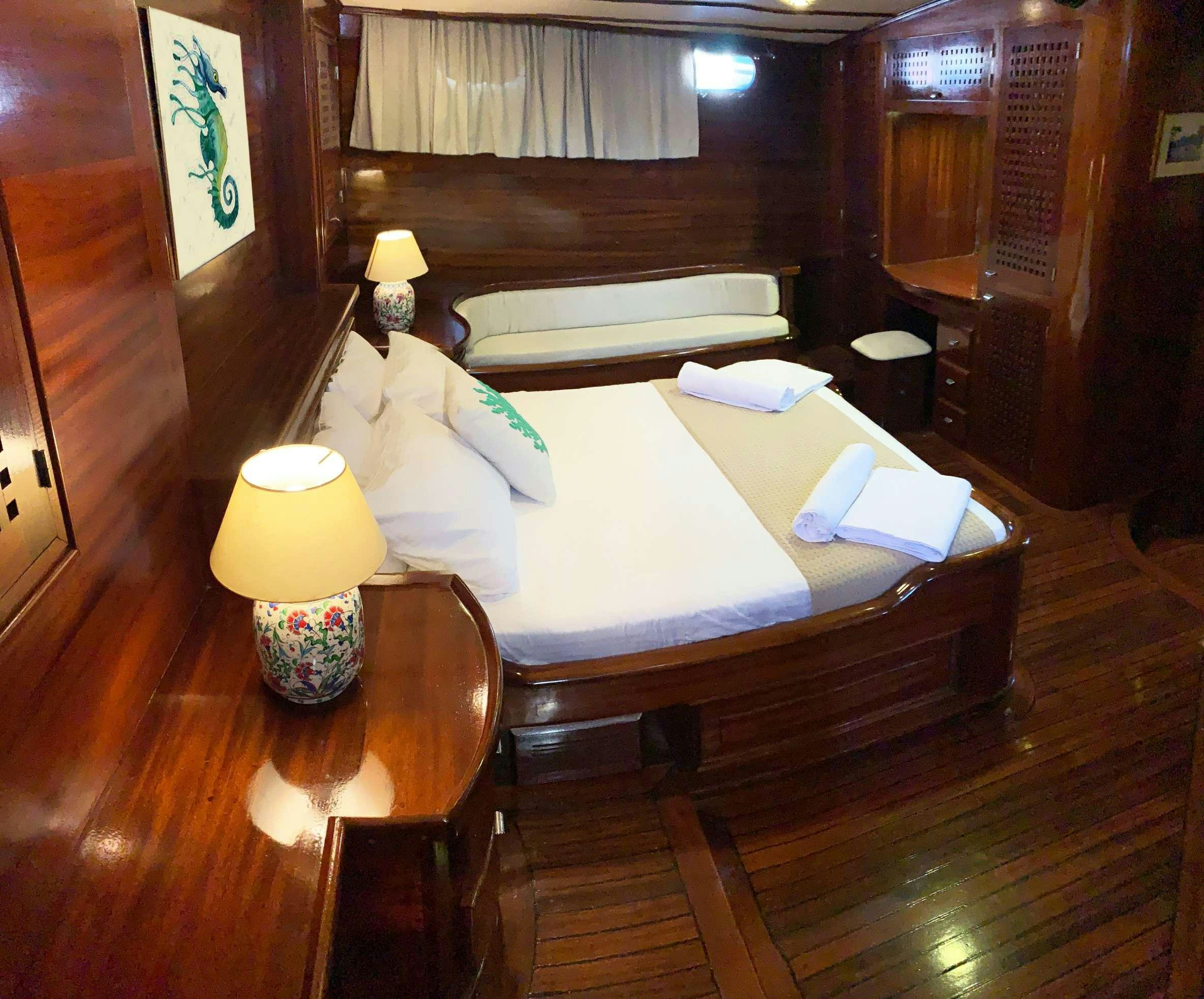 a room with a bed and a table aboard ELIANORA Yacht for Charter