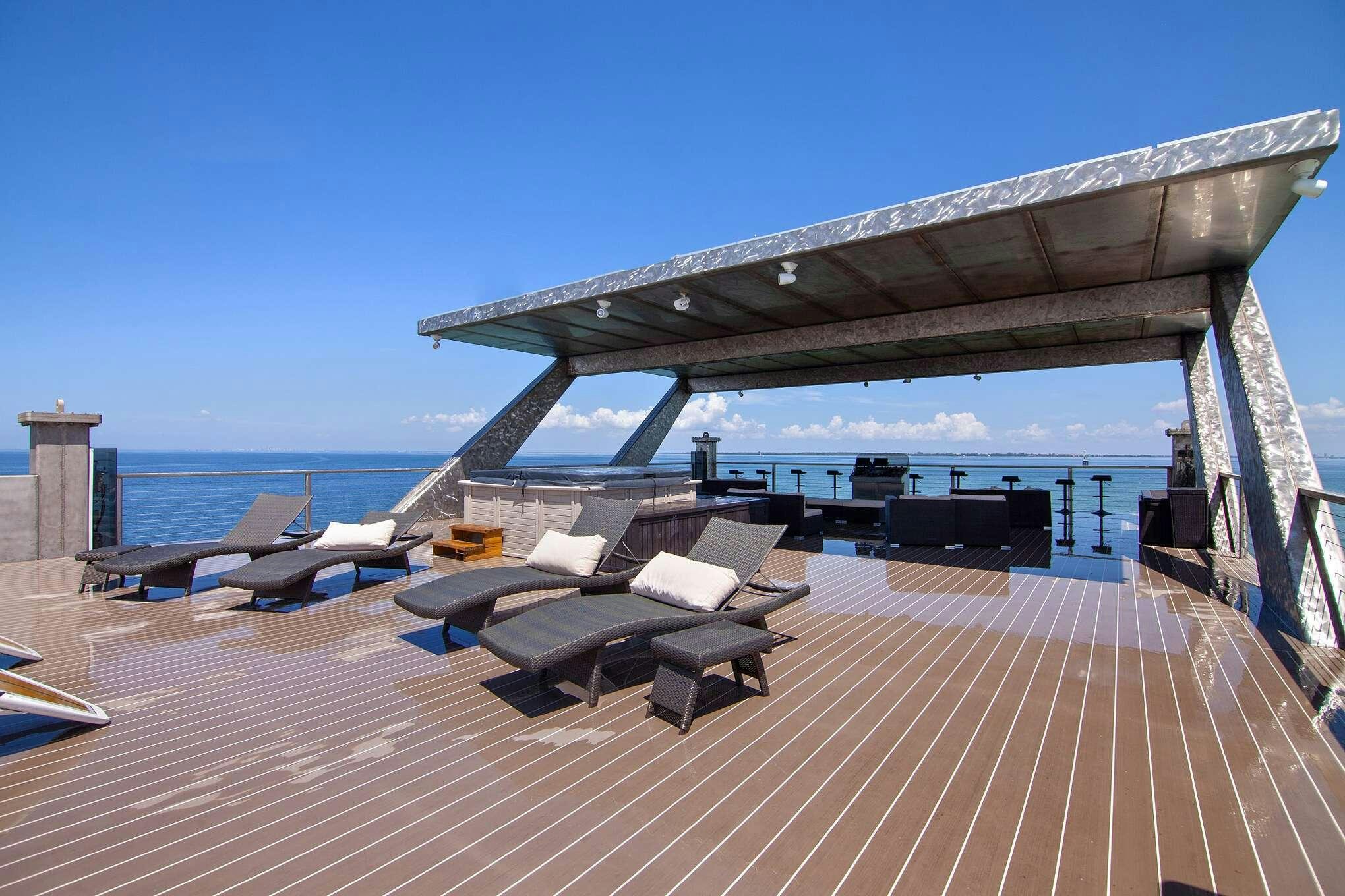 a deck with lounge chairs and a large body of water in the background aboard MANSION YACHT Yacht for Charter