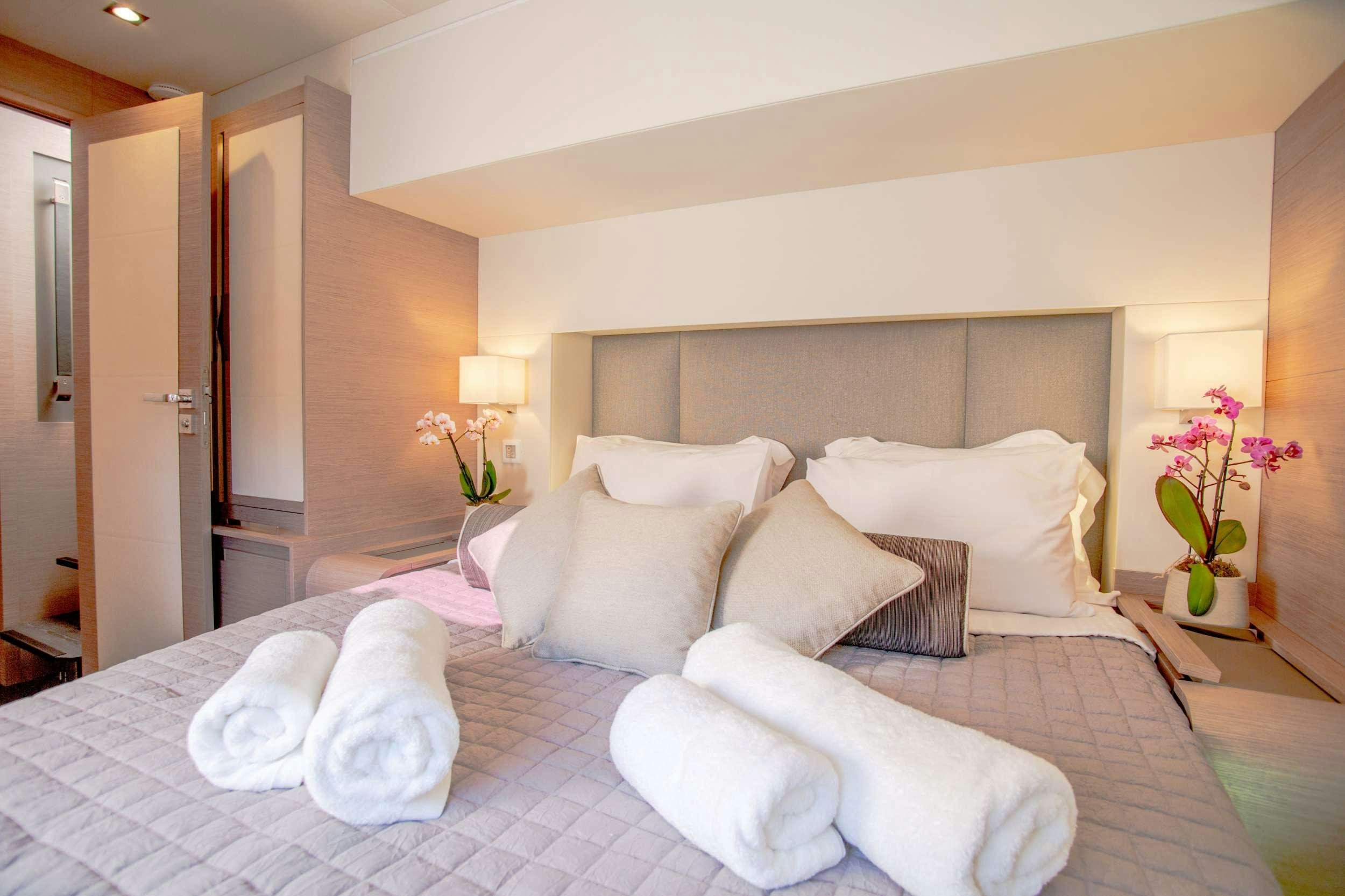 a bed with white pillows aboard ALENA Yacht for Charter