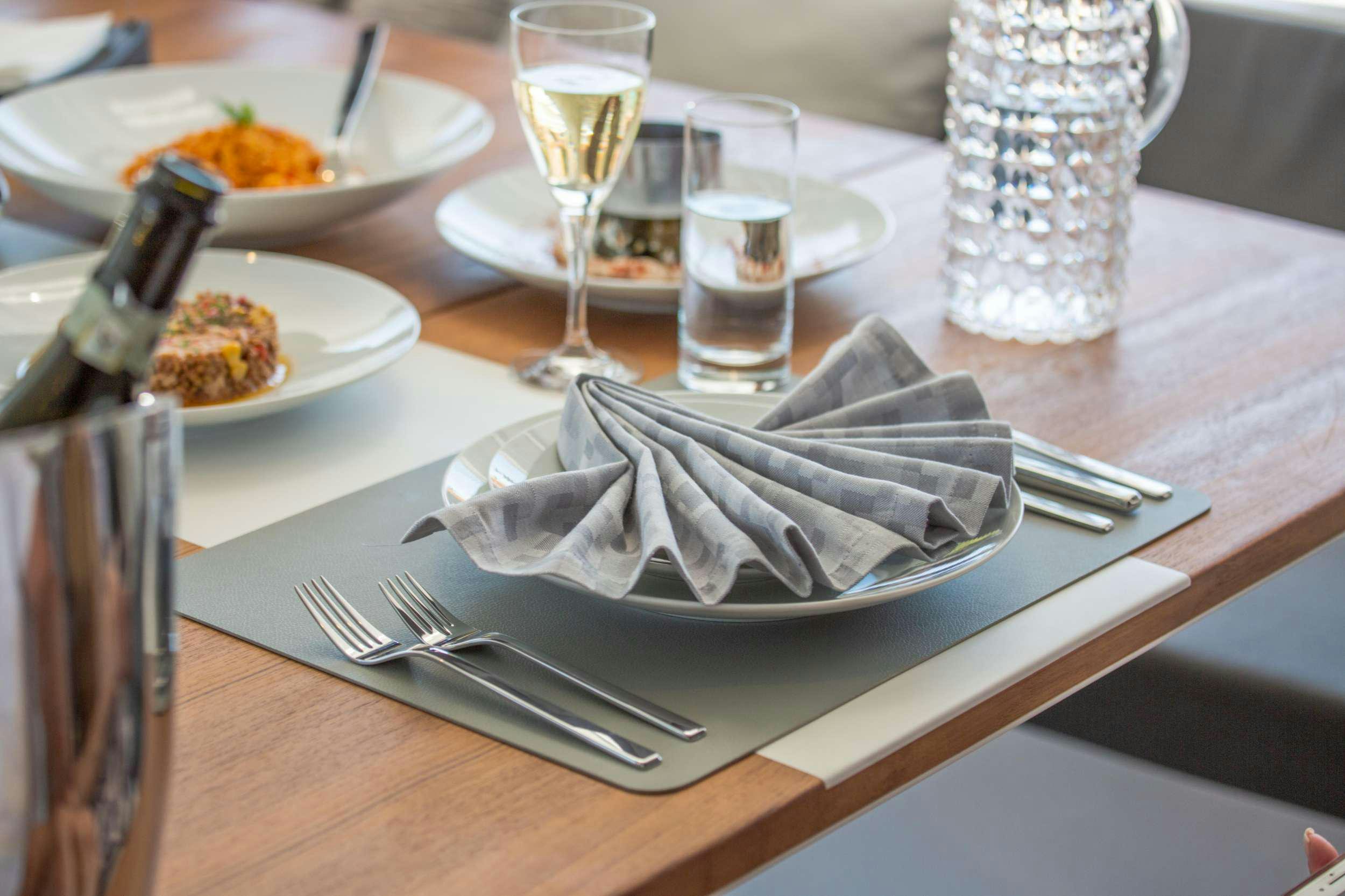 a table with plates and glasses aboard ALENA Yacht for Charter