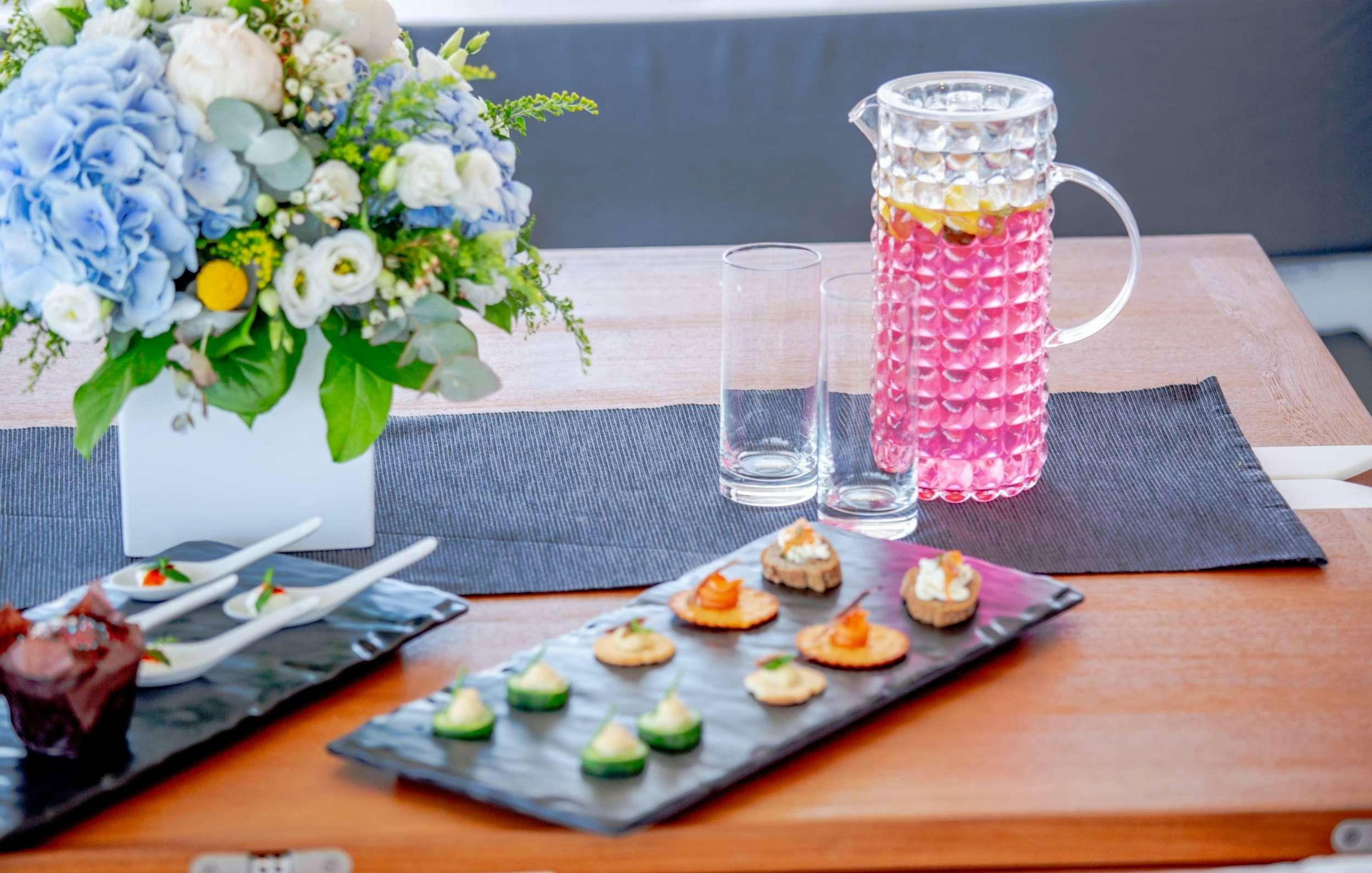 a table with food and drinks aboard ALENA Yacht for Charter