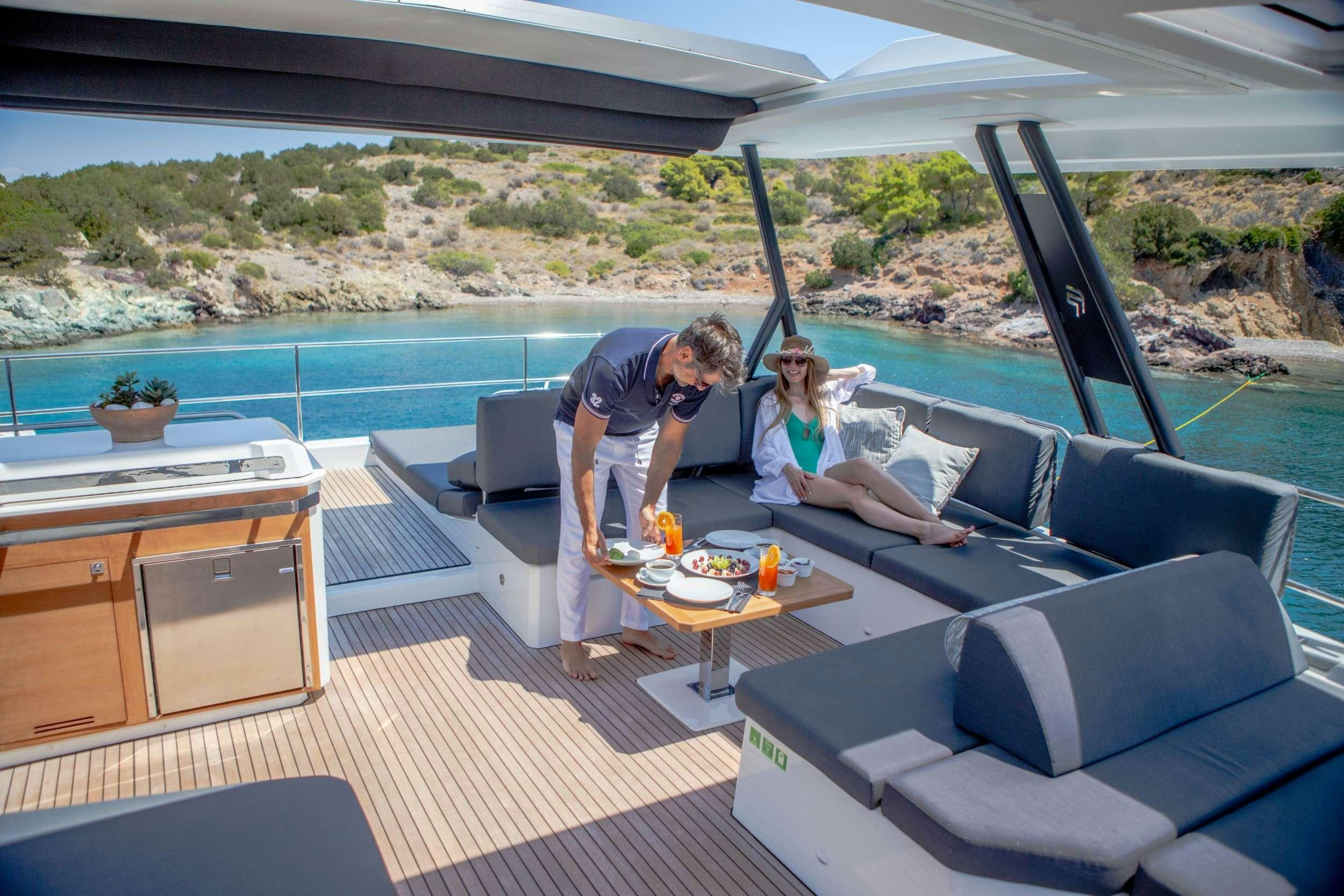 a couple sitting on a couch aboard ALENA Yacht for Charter