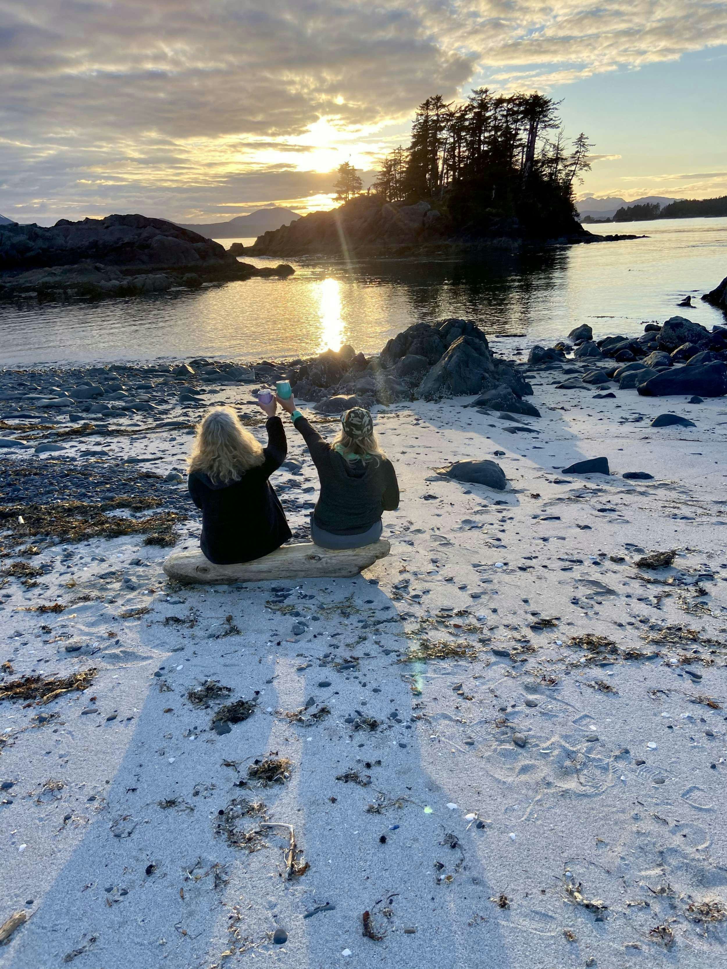 two people sitting on rocks near water aboard BEAR PAW Yacht for Charter