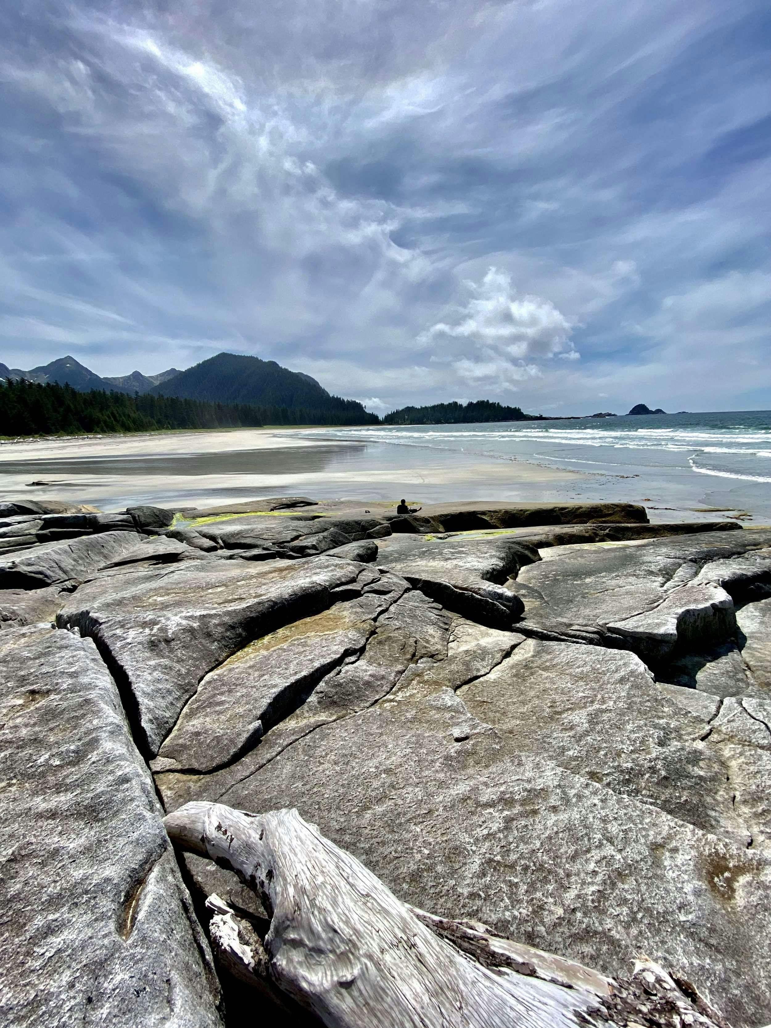 a rocky beach with a body of water and mountains in the background aboard BEAR PAW Yacht for Charter