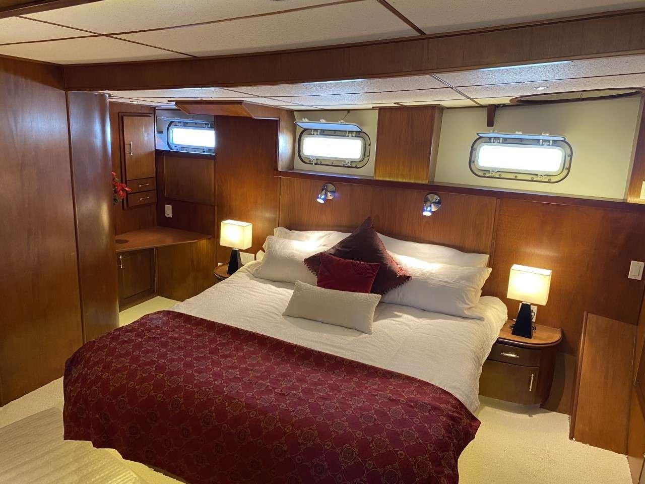 a bed with a white comforter aboard BEAR PAW Yacht for Charter