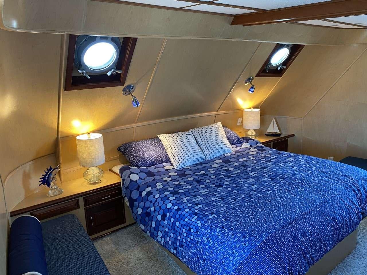 a bed with blue sheets aboard BEAR PAW Yacht for Charter