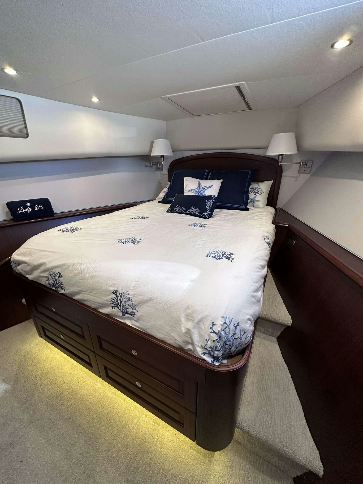a bedroom with a bed and a desk aboard LADY B Yacht for Charter