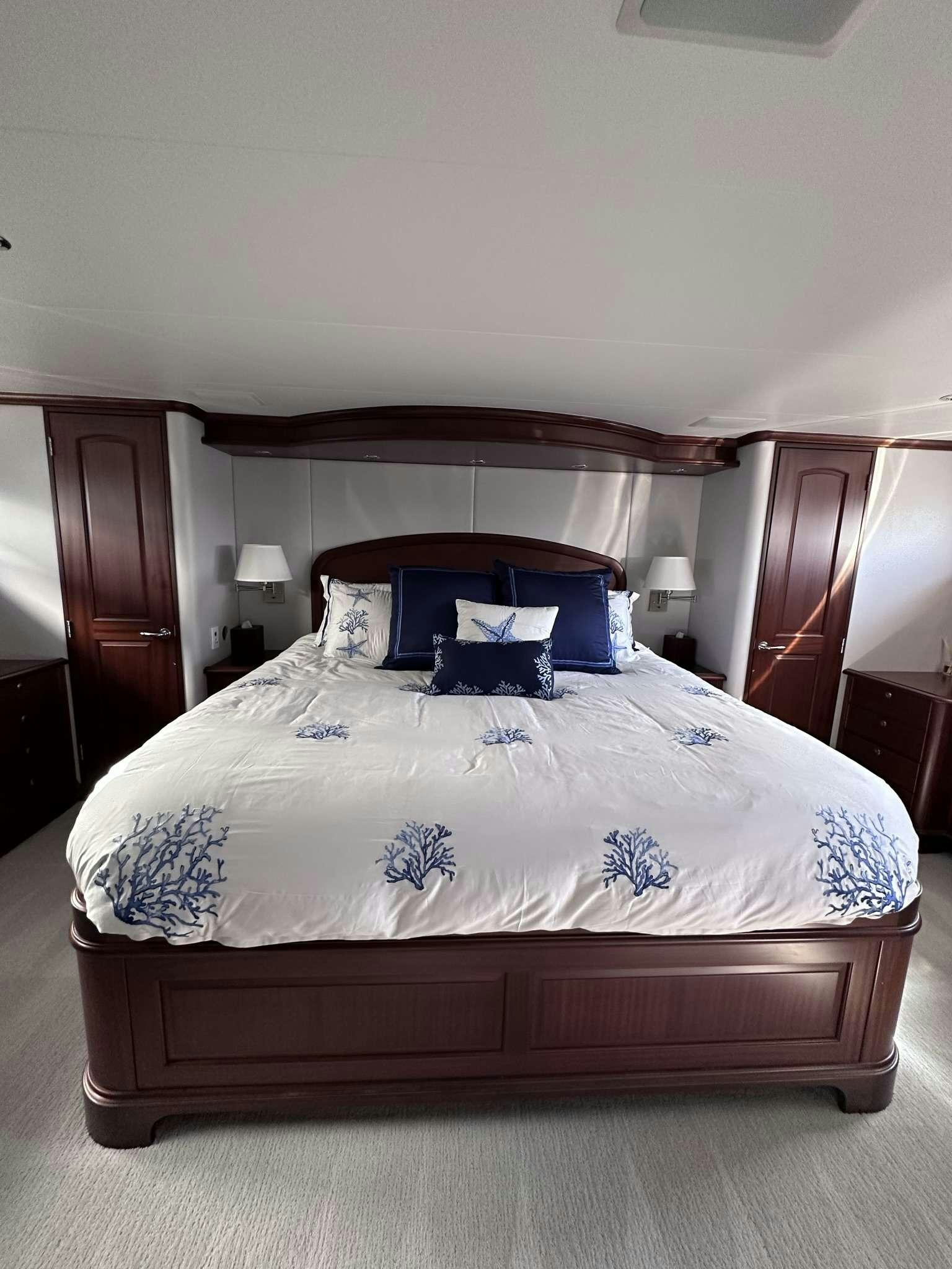 a bed with a blue pillow aboard LADY B Yacht for Charter
