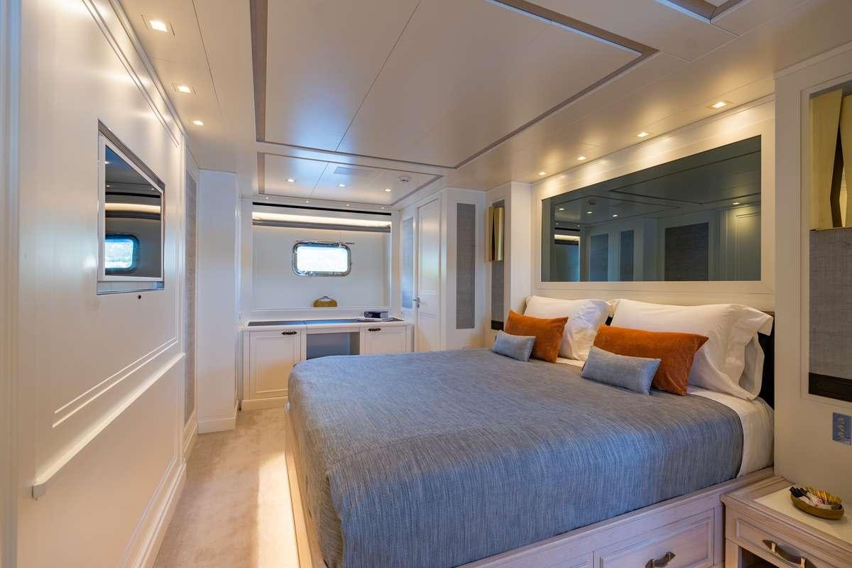 a bedroom with a bed and a tv on the wall aboard VALENTINA II Yacht for Charter