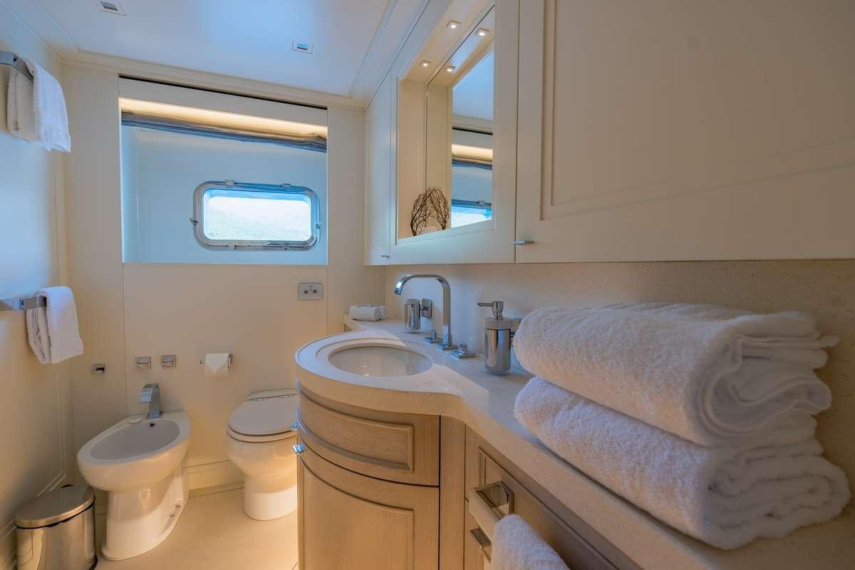 a bathroom with a sink toilet and a mirror aboard VALENTINA II Yacht for Charter
