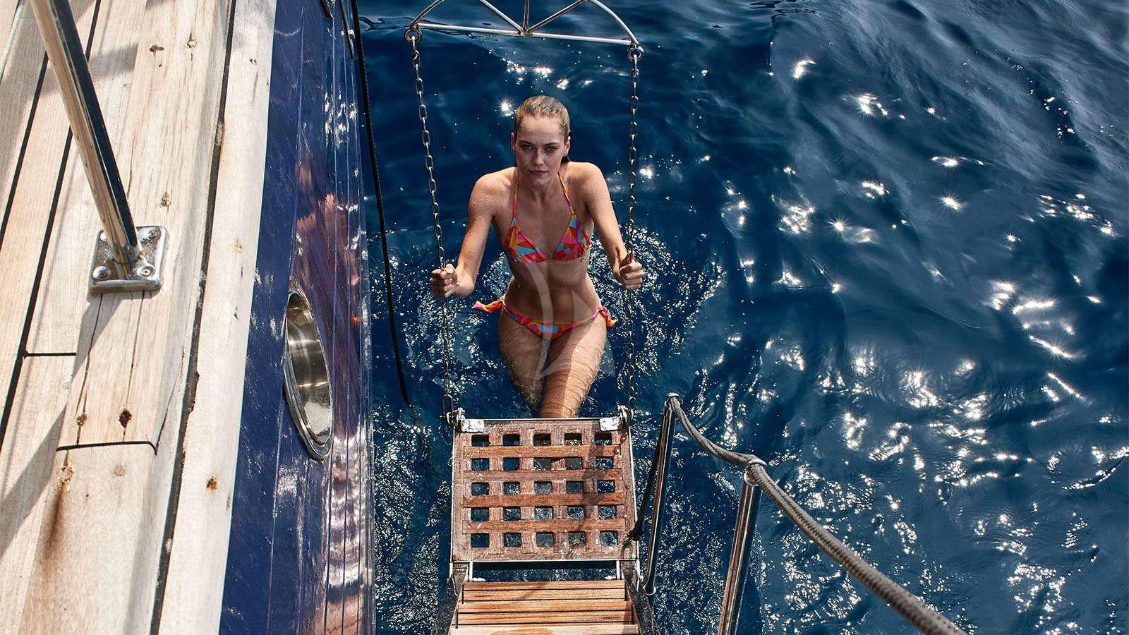 a child jumping off a boat aboard ALMYRA Yacht for Charter