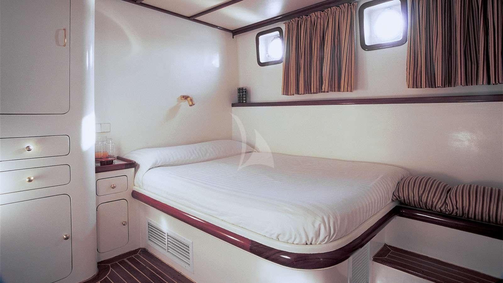 a bed with white sheets aboard ALMYRA Yacht for Charter