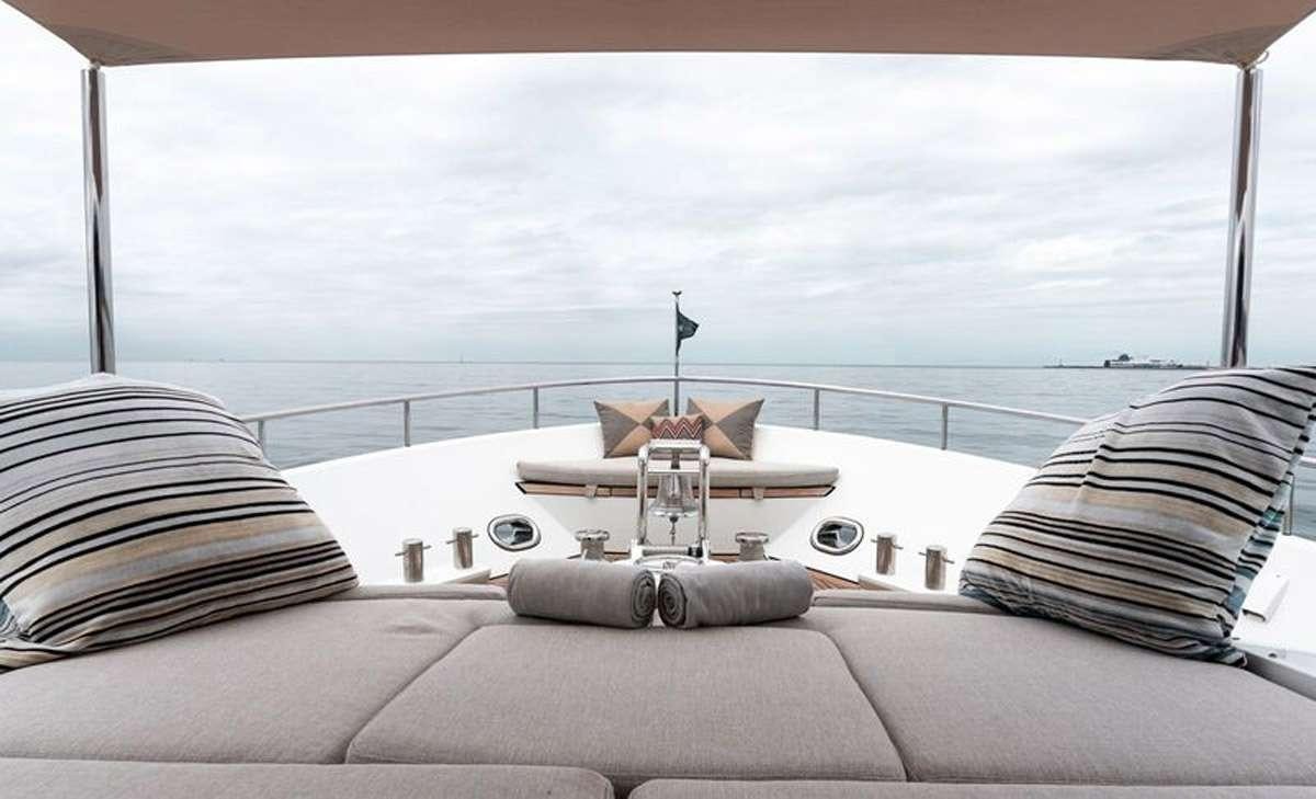 a large white sofa with a white and brown pillow and a white wall with a white railing and aboard HEERLIJCKHEID Yacht for Charter