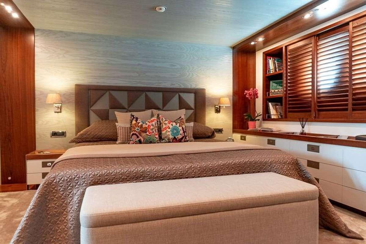 a bed with a white bed spread aboard HEERLIJCKHEID Yacht for Charter