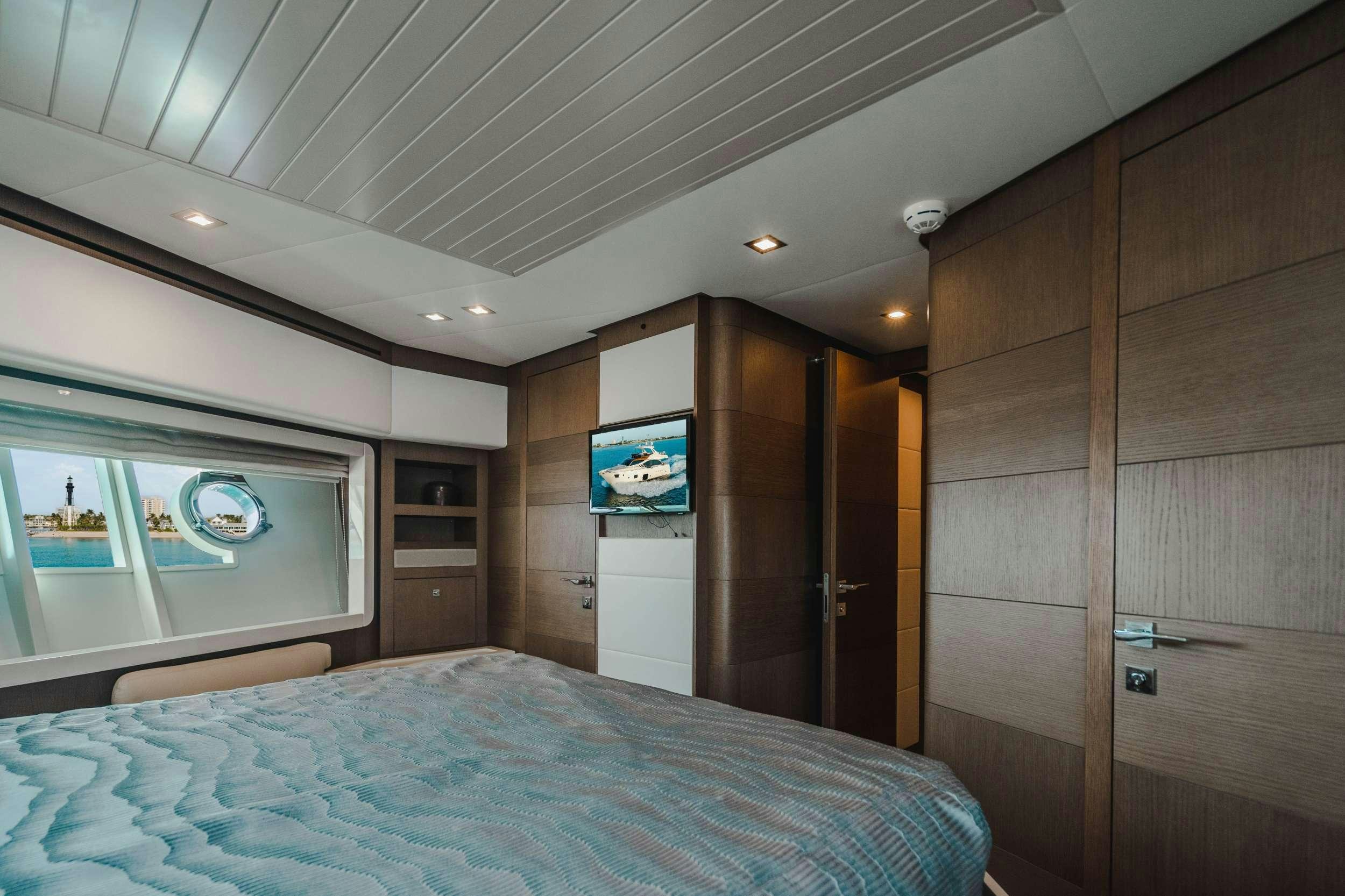 a bedroom with a bed and a television aboard MIRABILIS Yacht for Charter