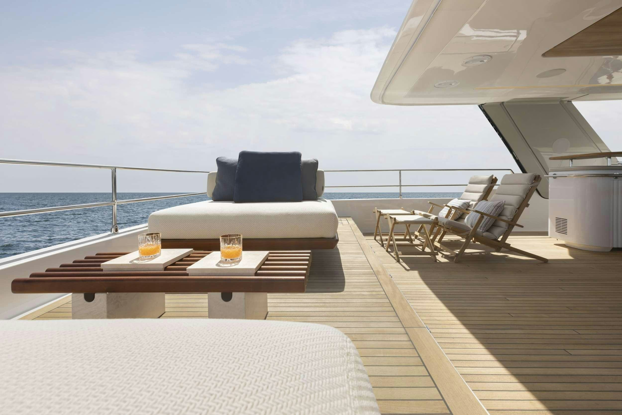 a deck with a large sofa and a table on it aboard PRONTO Yacht for Charter