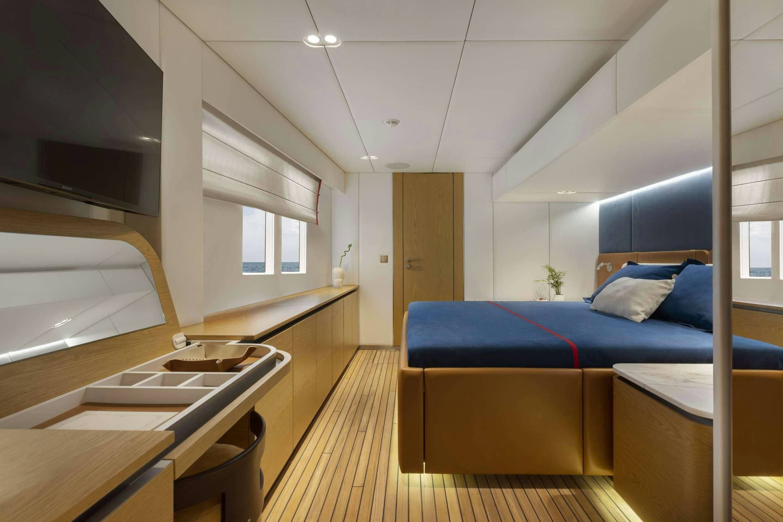 a bedroom with a blue bed aboard PRONTO Yacht for Charter