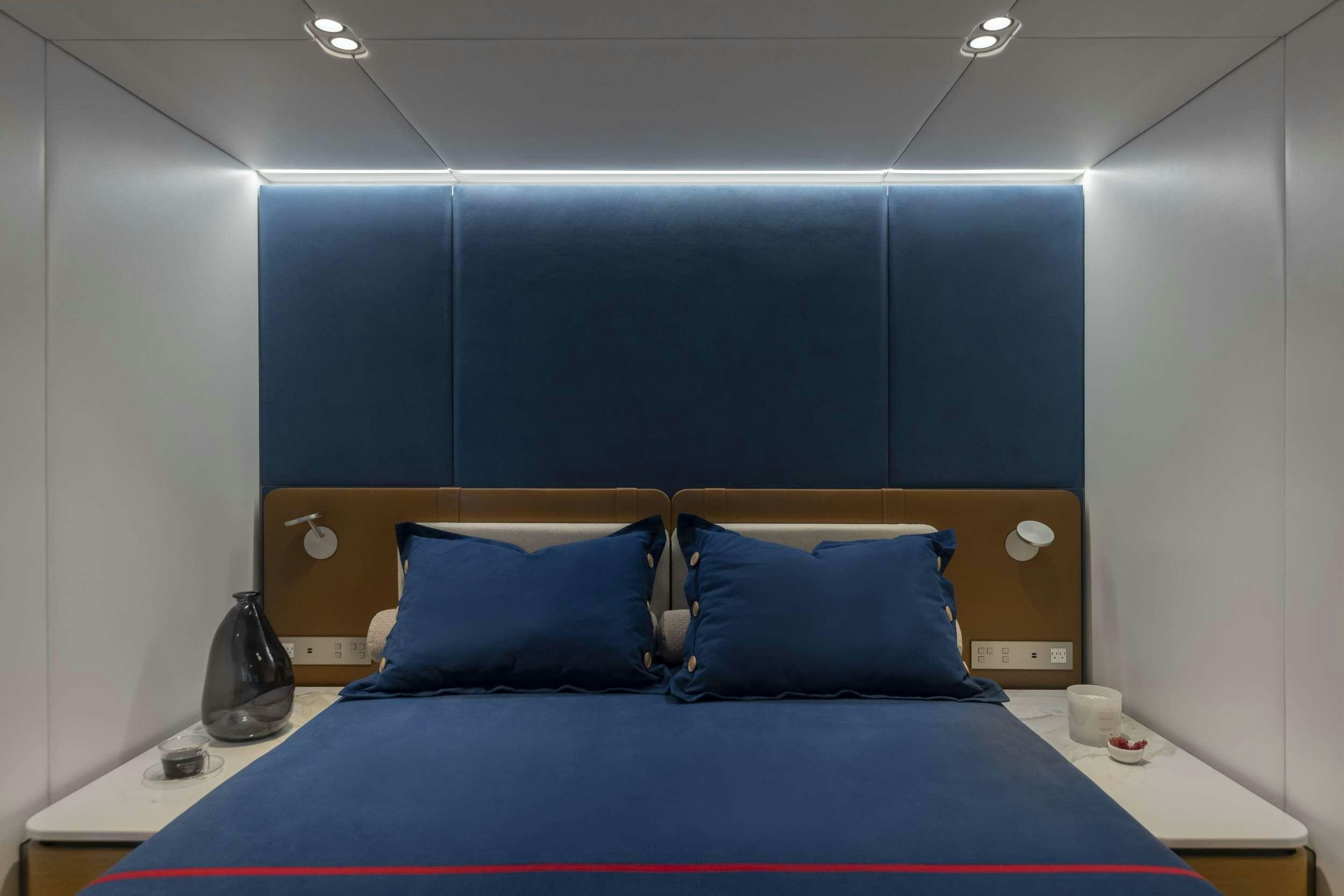 a bed with a blue blanket aboard PRONTO Yacht for Charter