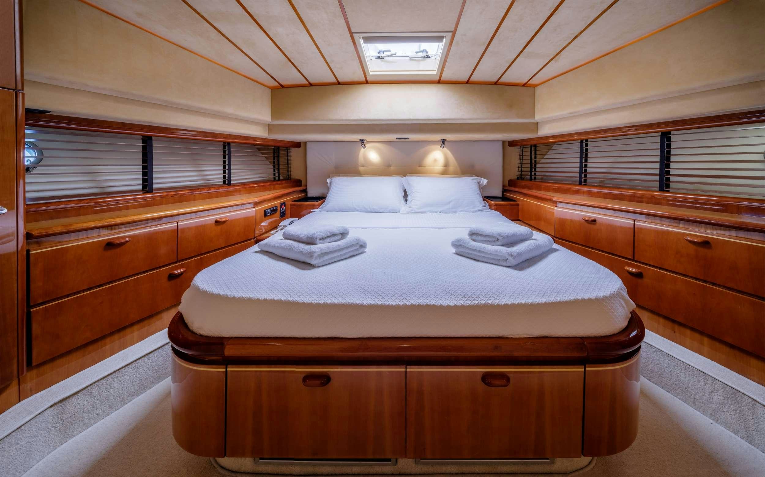 a room with a bed and a dresser aboard MY WAY Yacht for Charter