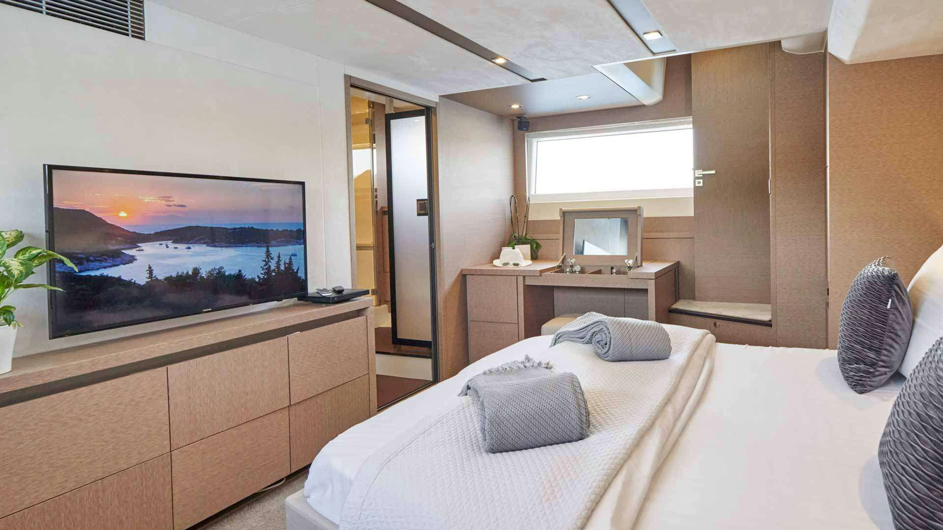 a bedroom with a tv and a bed aboard SIMULL Yacht for Charter