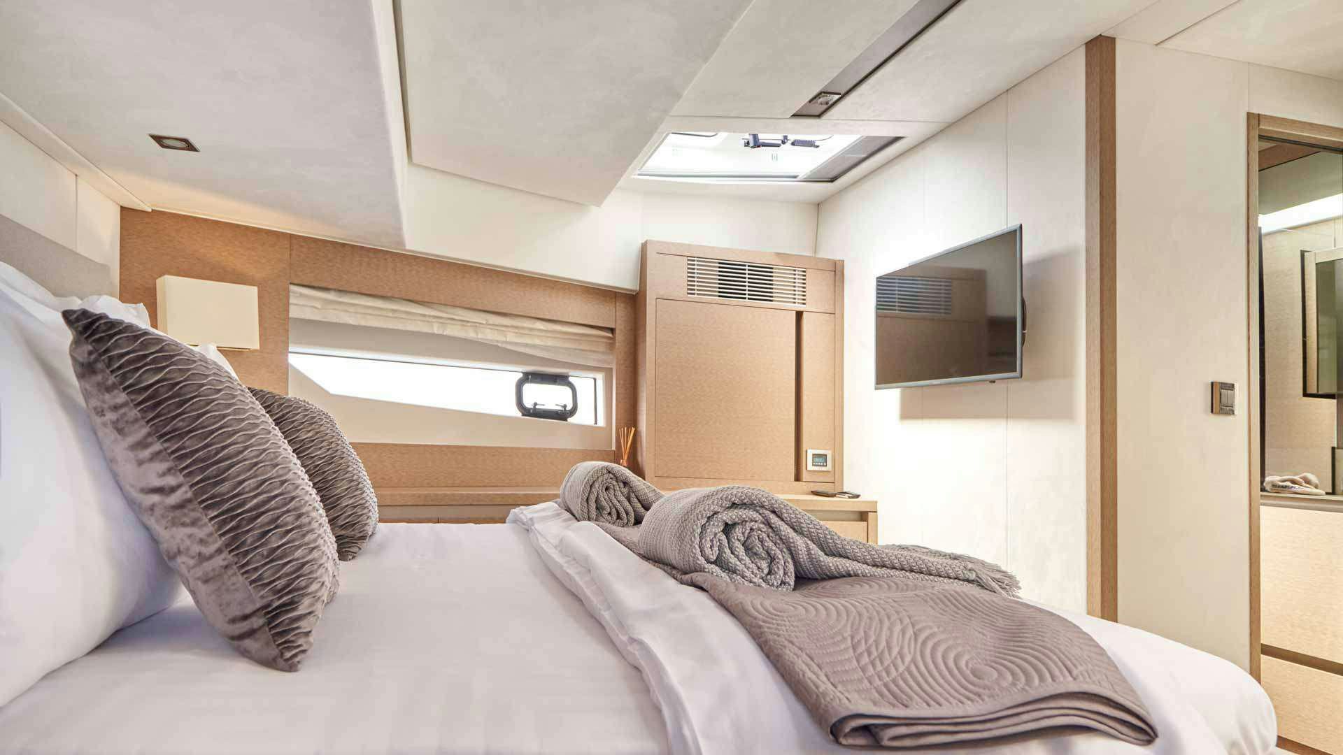 a bed with a pillow and a television on it aboard SIMULL Yacht for Charter