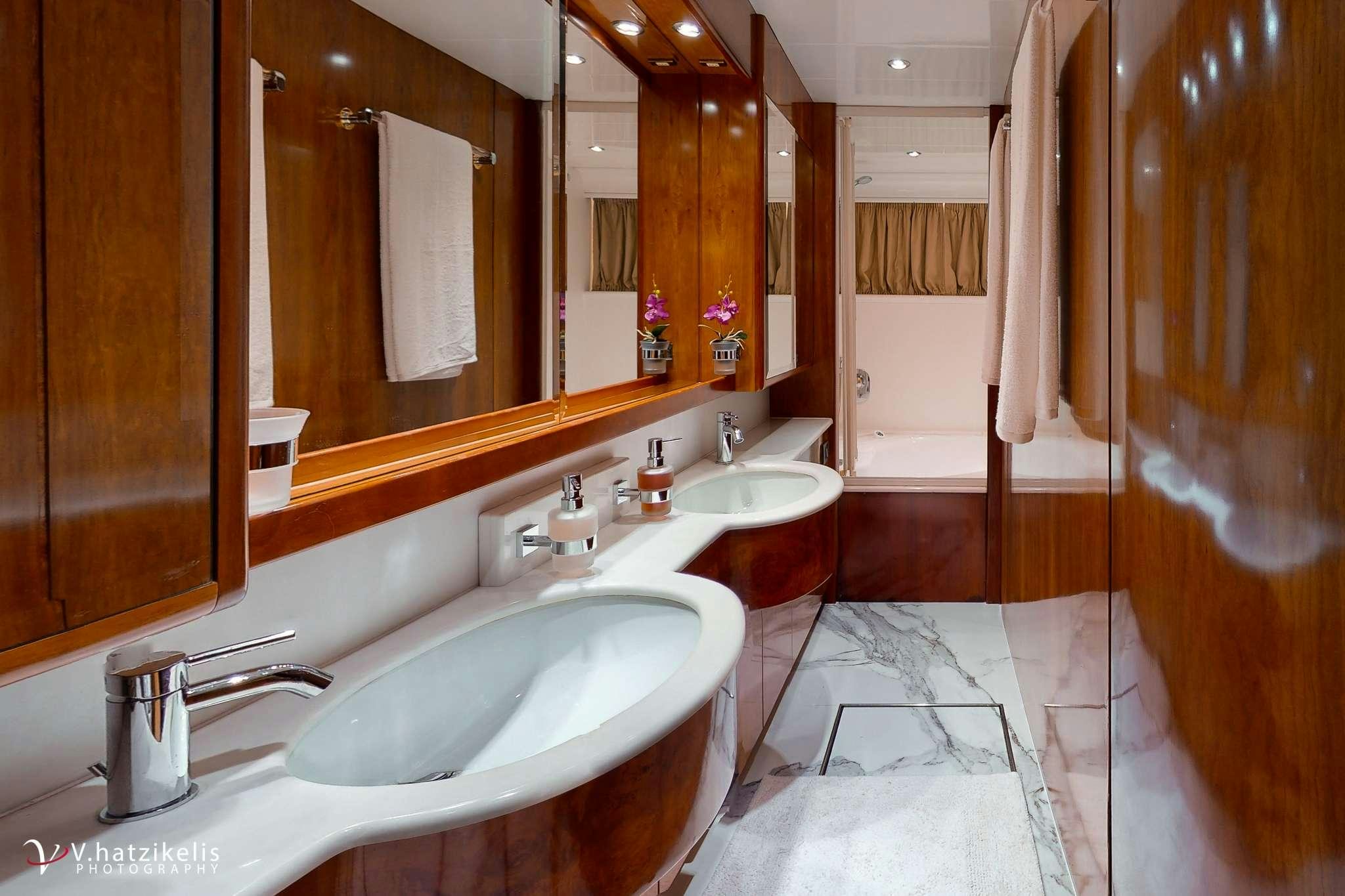 a bathroom with two sinks and a large mirror aboard NATASSA Yacht for Charter