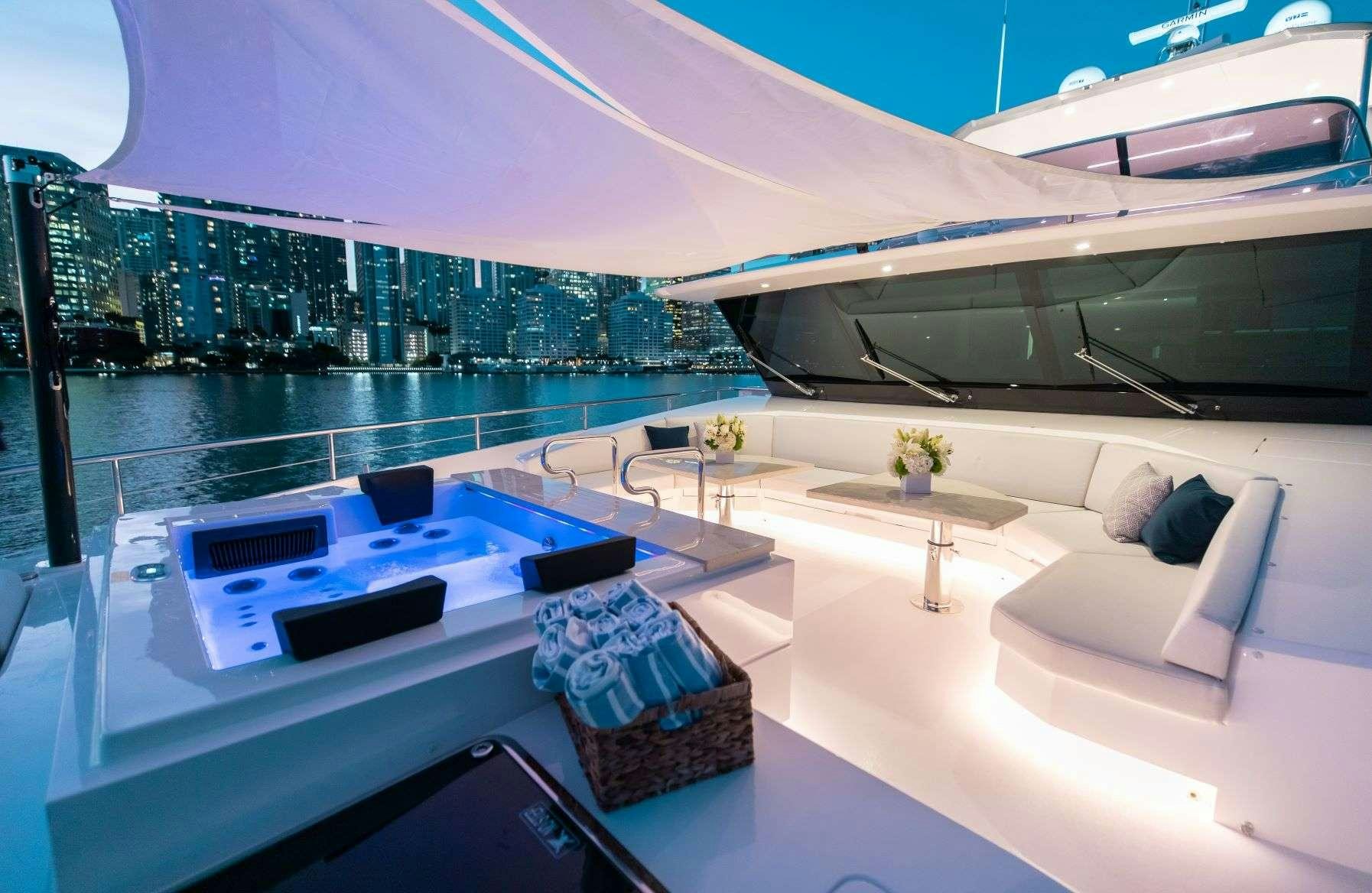 a room with a large white sofa and a table with a laptop on it aboard FREEDOM Yacht for Charter