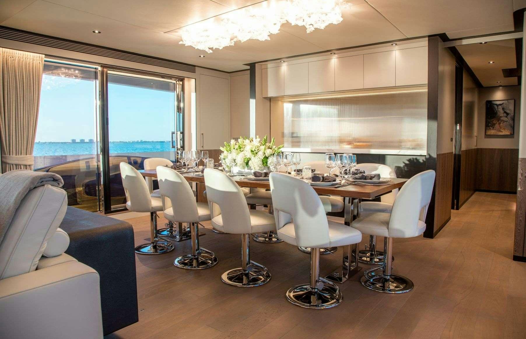 a room with tables and chairs aboard FREEDOM Yacht for Charter