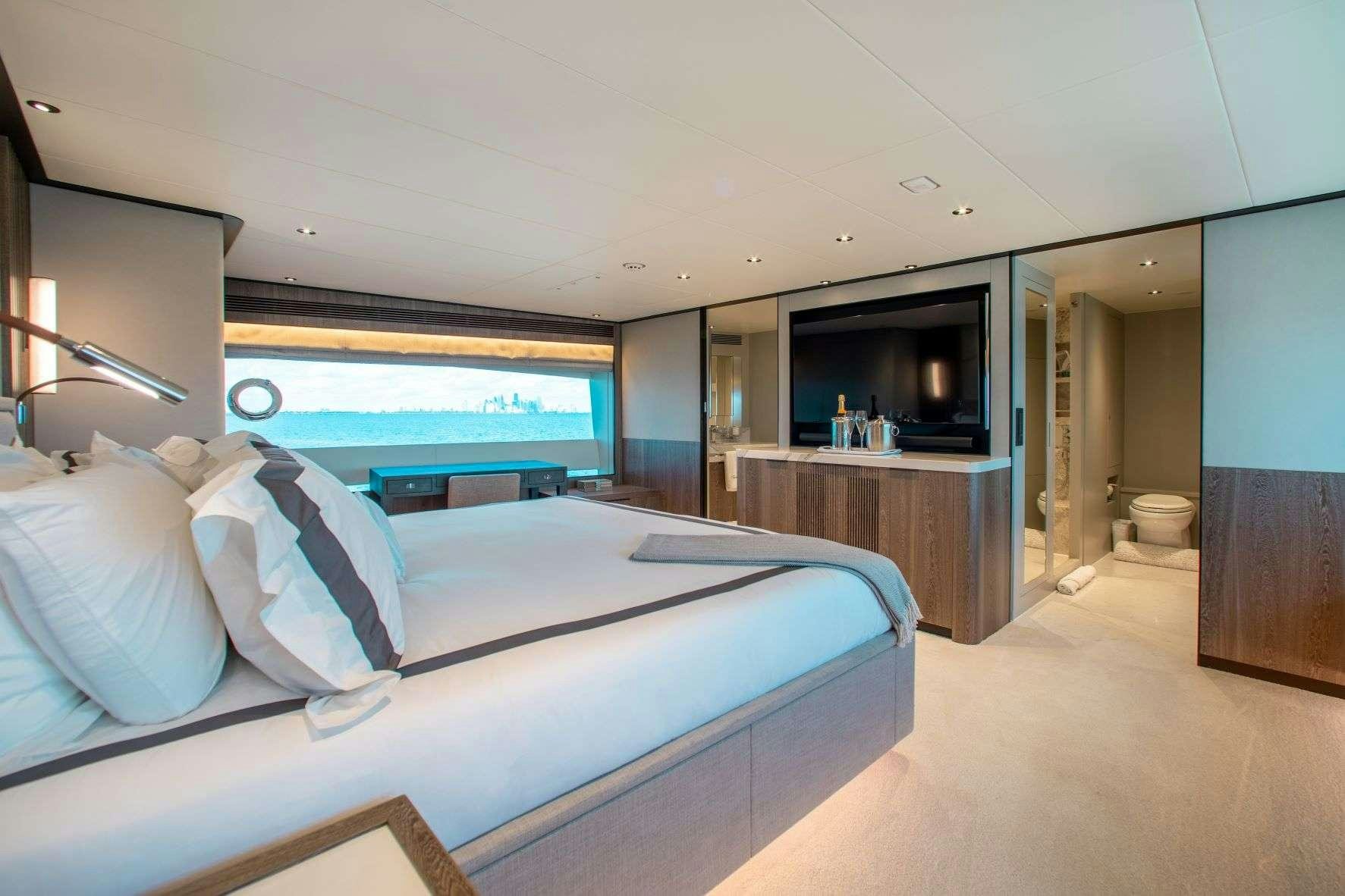 a room with a bed and a television aboard FREEDOM Yacht for Charter