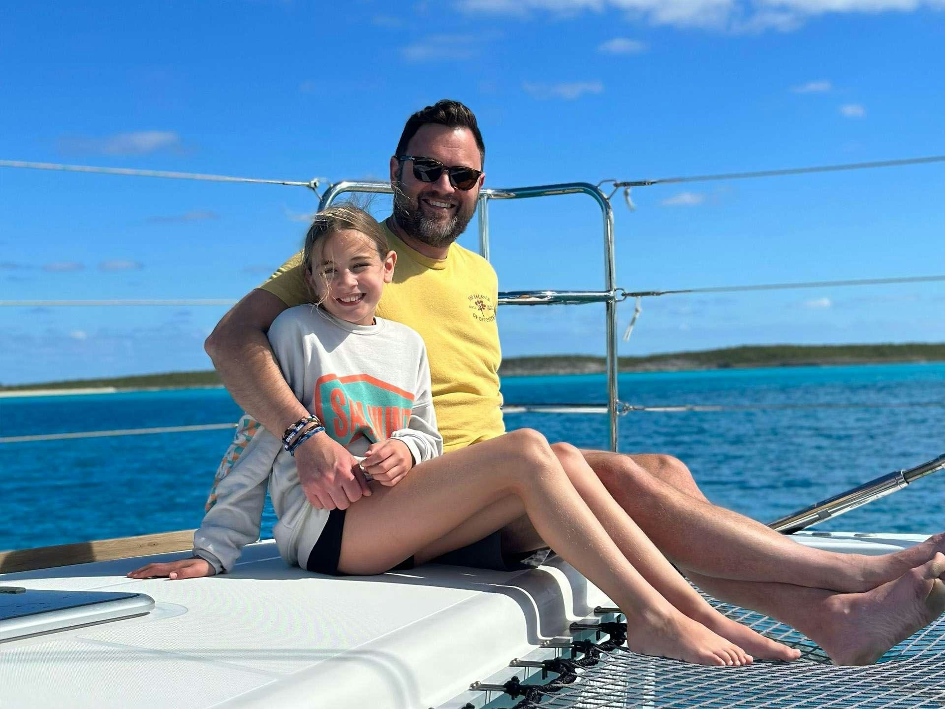 a man and a woman sitting on a boat with a baby aboard BLUE CAT Yacht for Charter