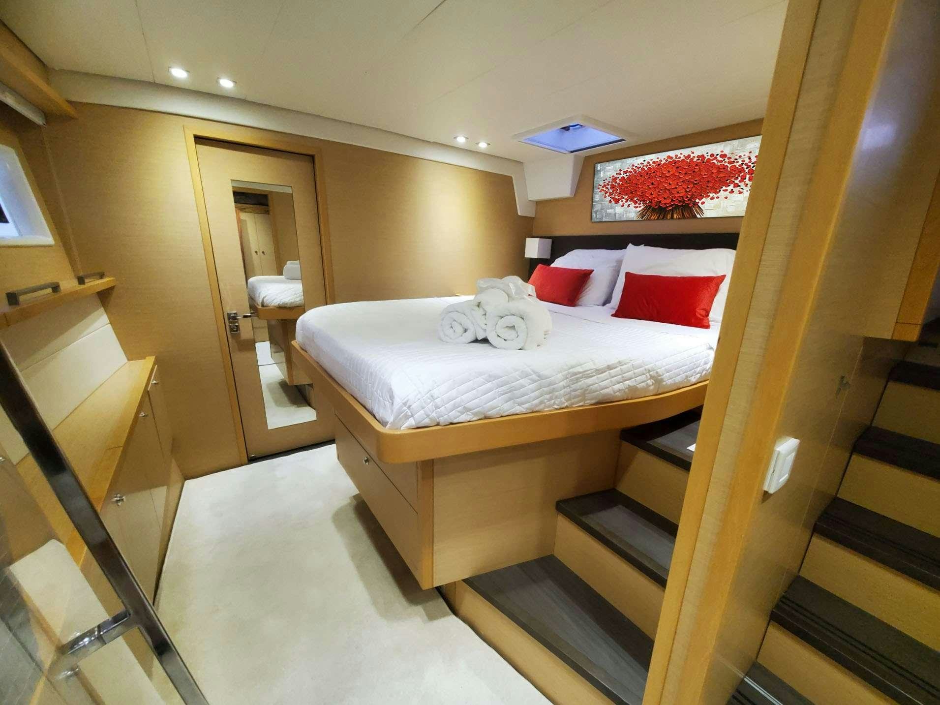 a room with a bed and a desk aboard BLUE CAT Yacht for Charter