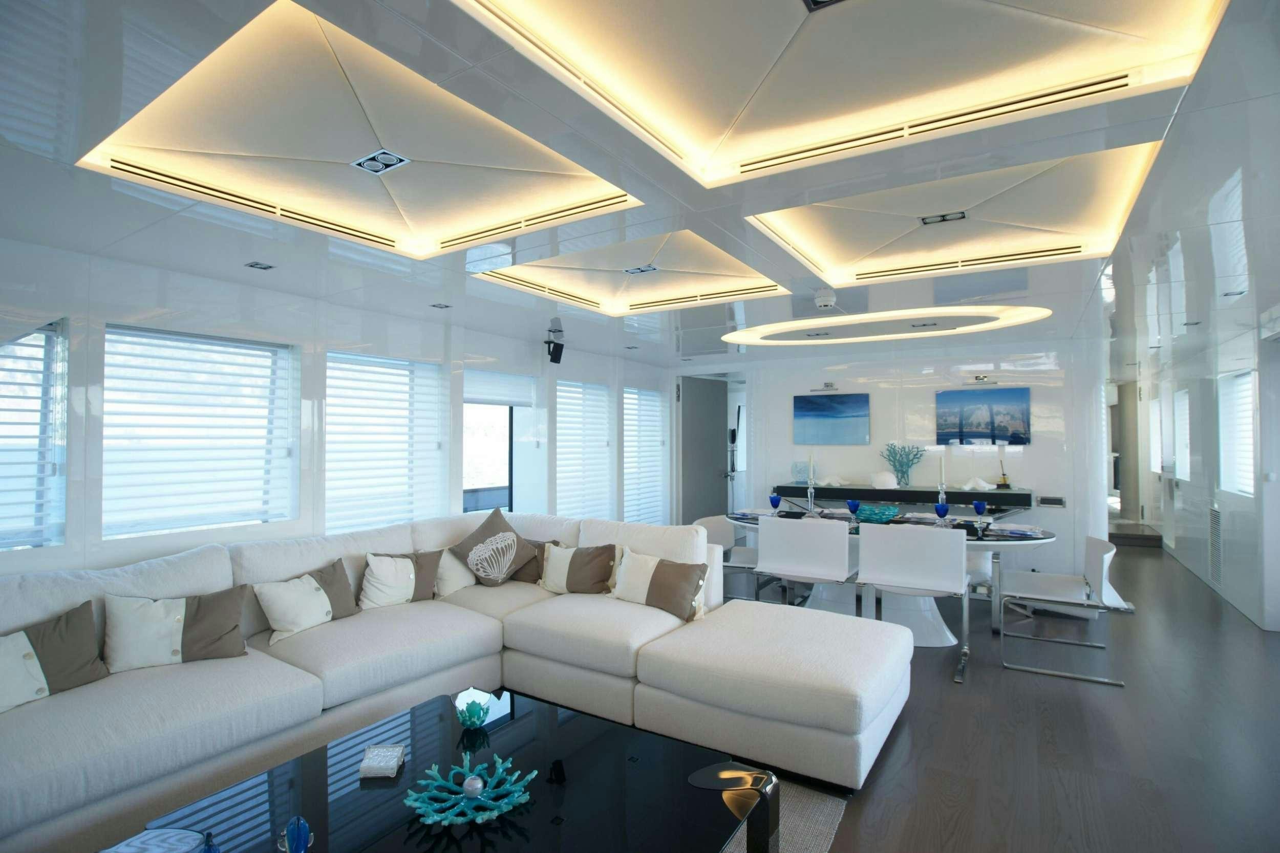 a living room with white furniture aboard REM Yacht for Charter