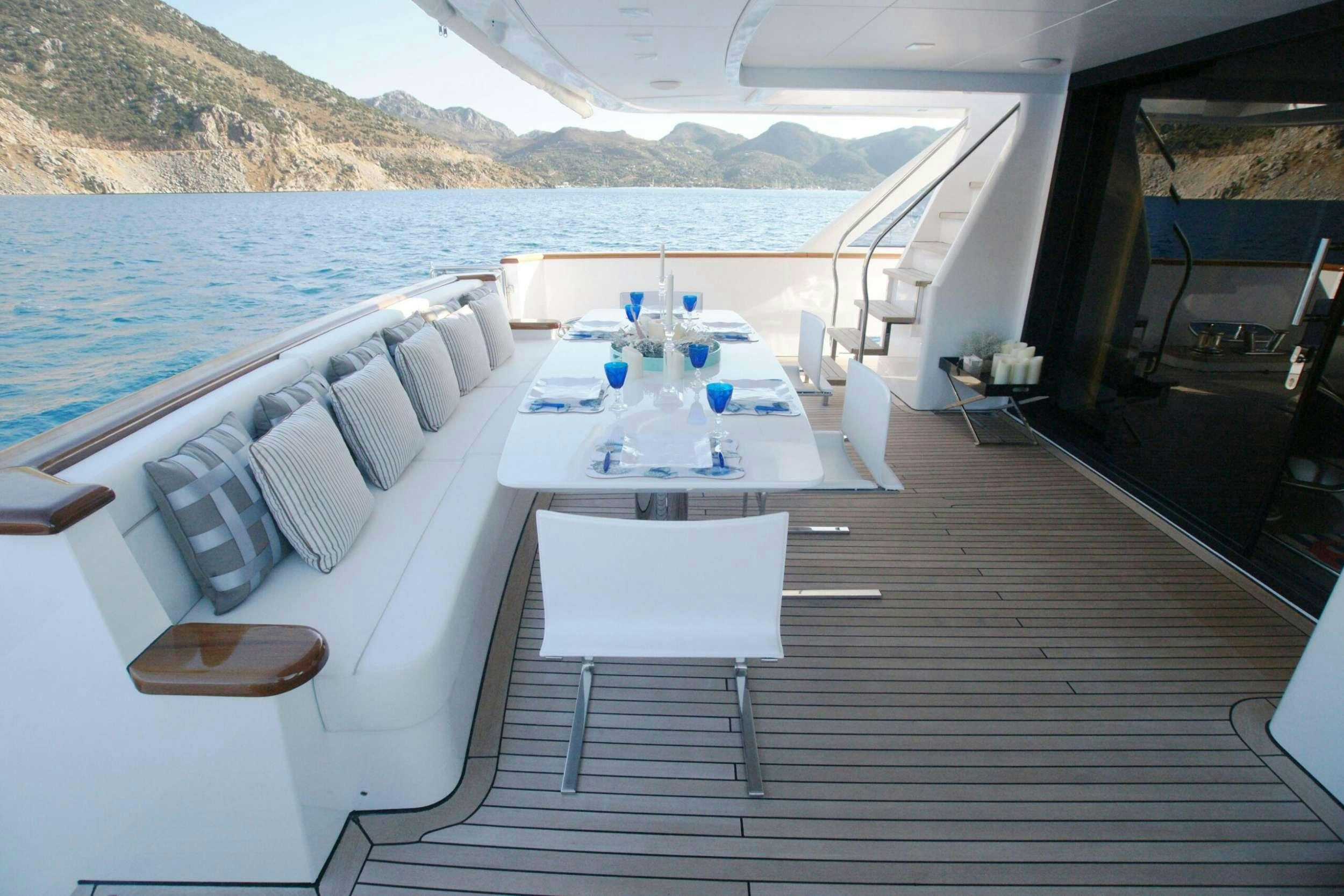 a table and chairs on a deck aboard REM Yacht for Charter