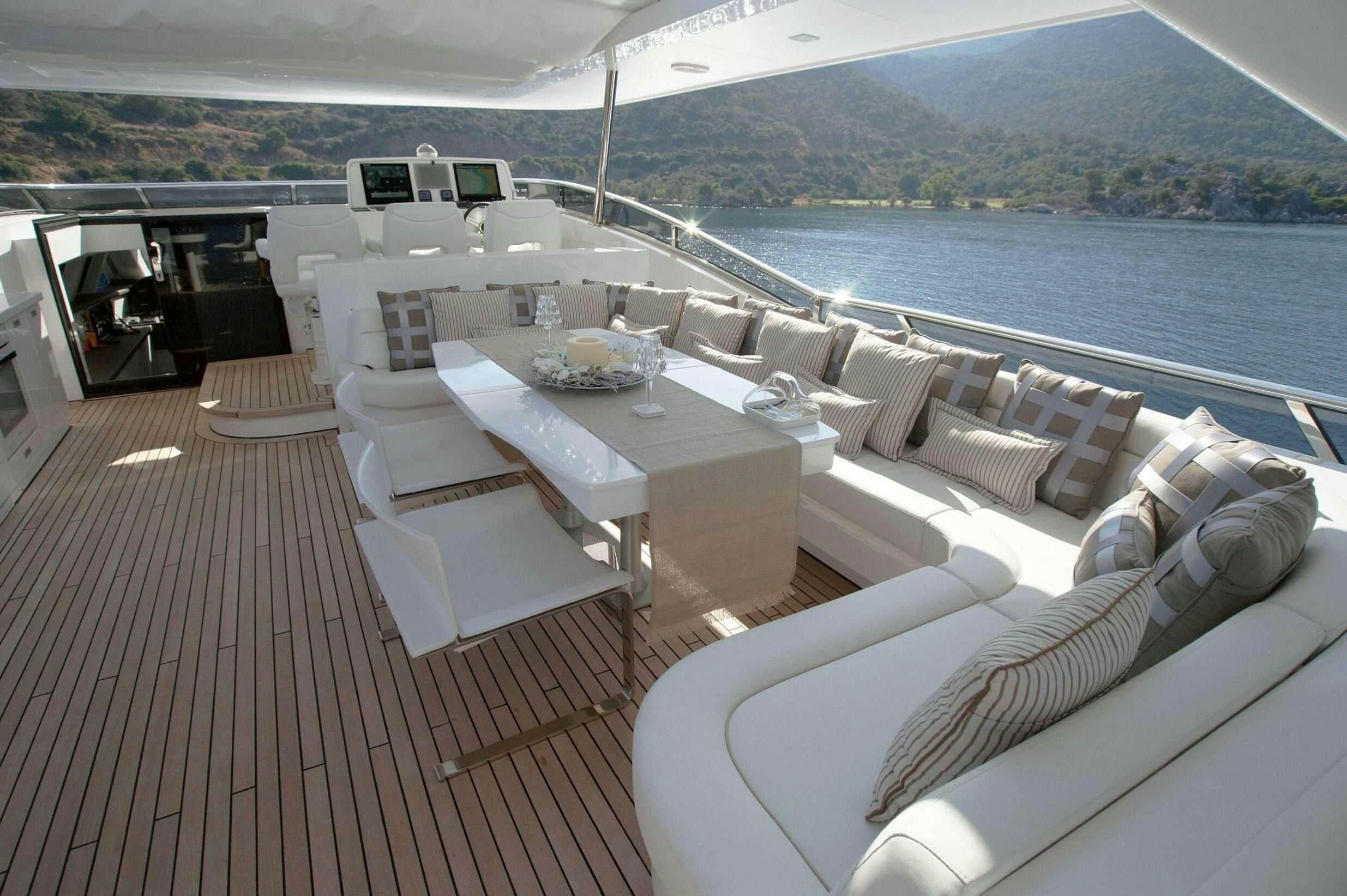 a deck with a table and chairs on it aboard REM Yacht for Charter