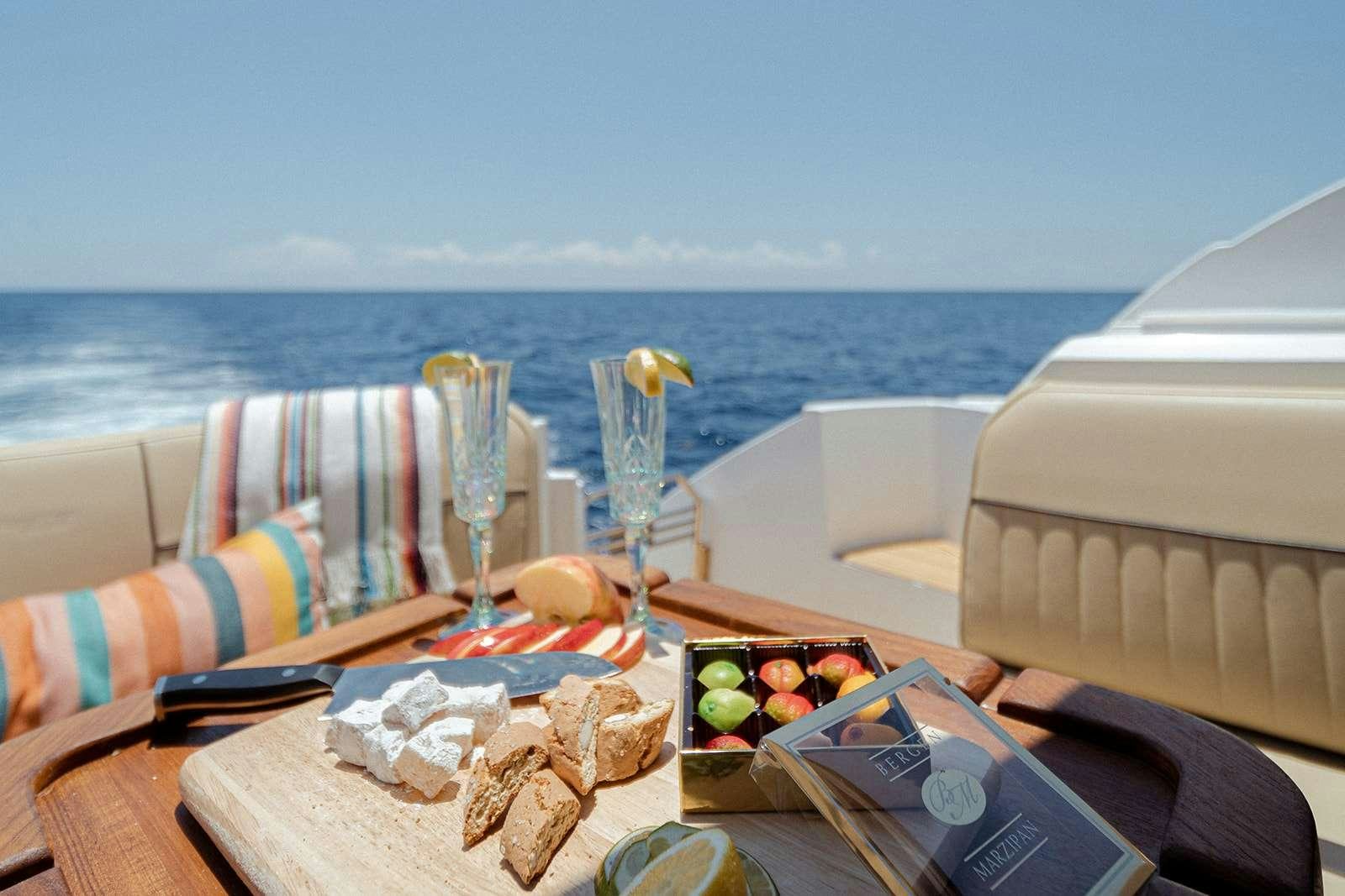 a table with food and wine on it aboard EPIC Yacht for Charter