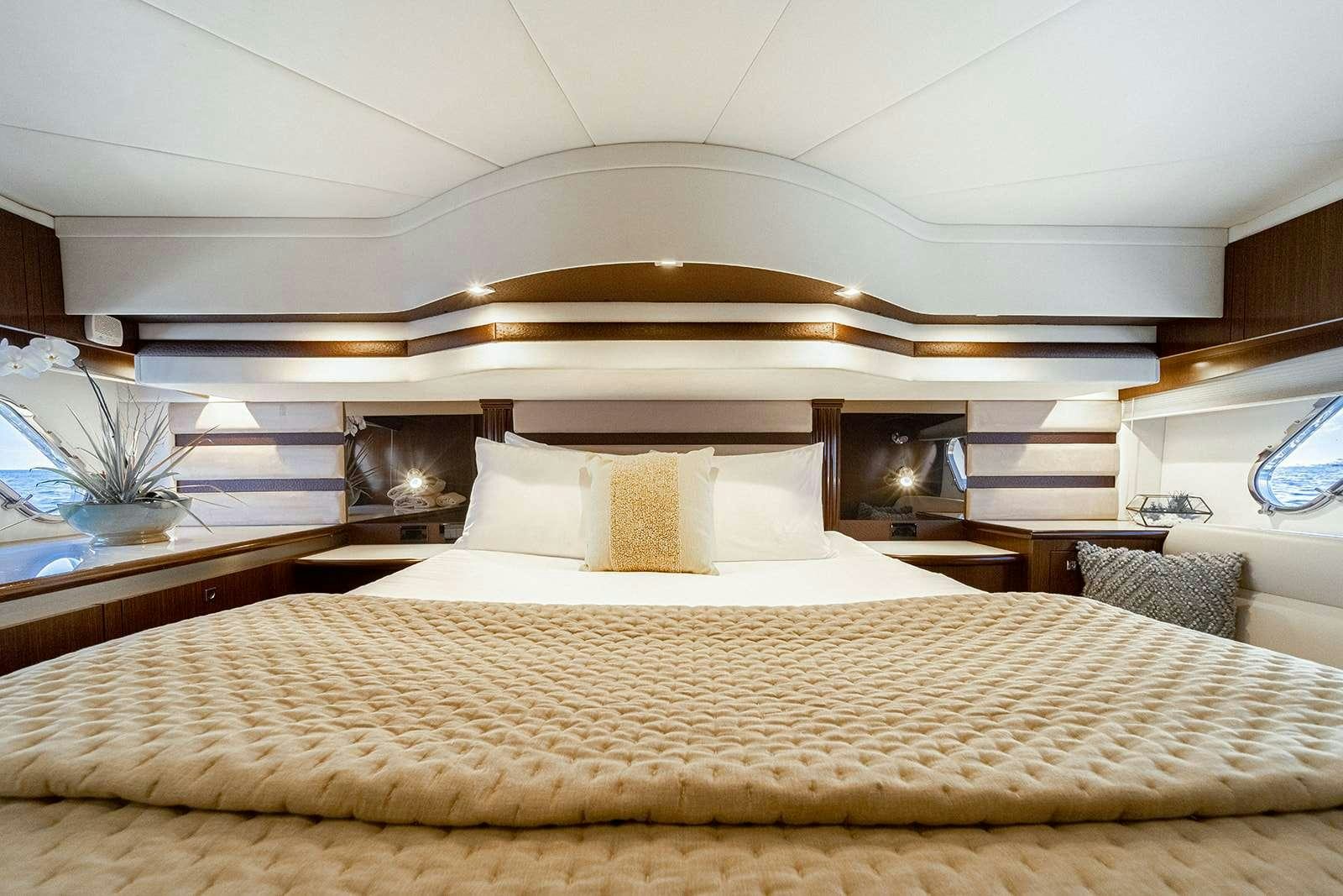 a bed with a large mirror above it aboard EPIC Yacht for Charter