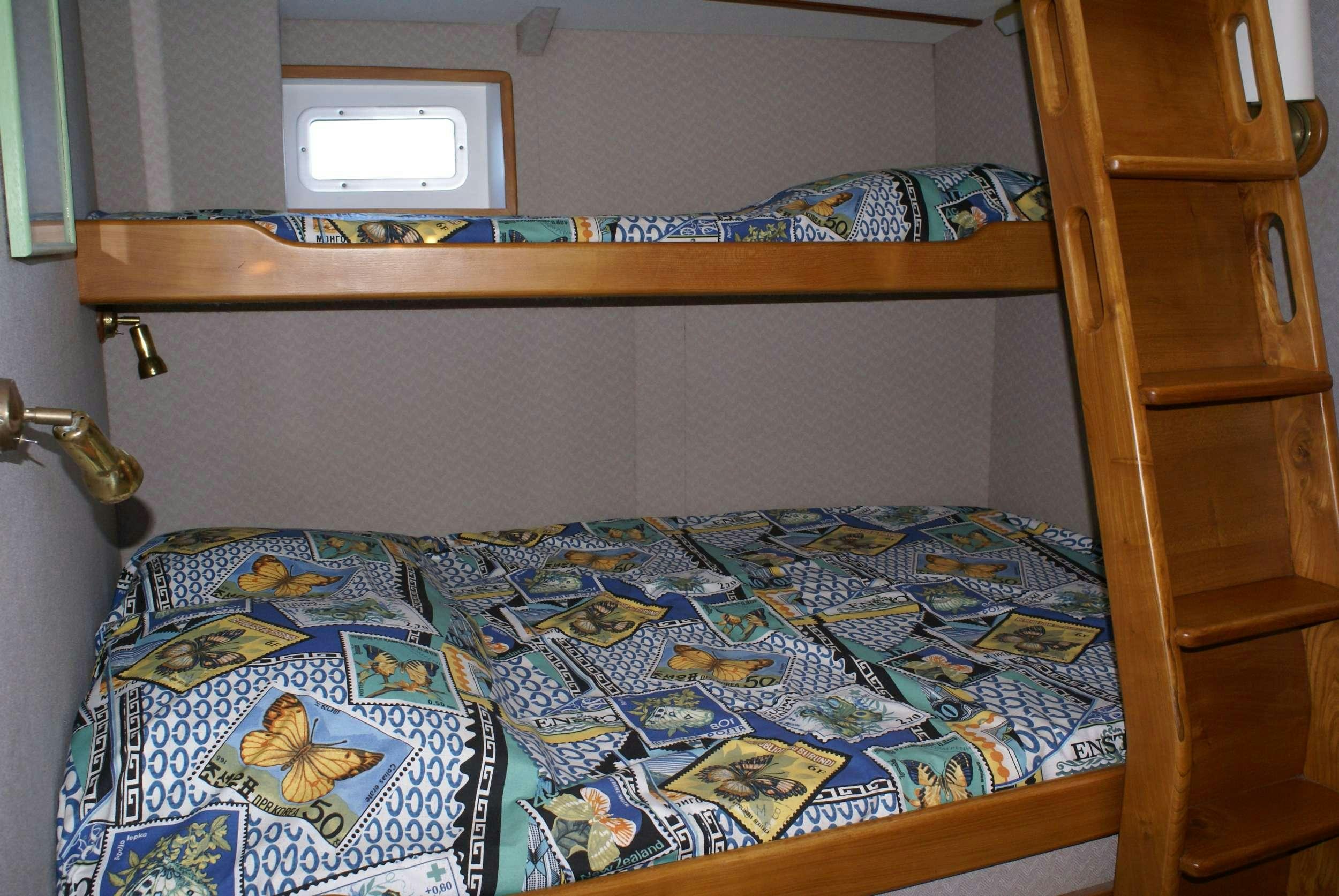 a bed with a blue comforter aboard JAIPUR Yacht for Charter