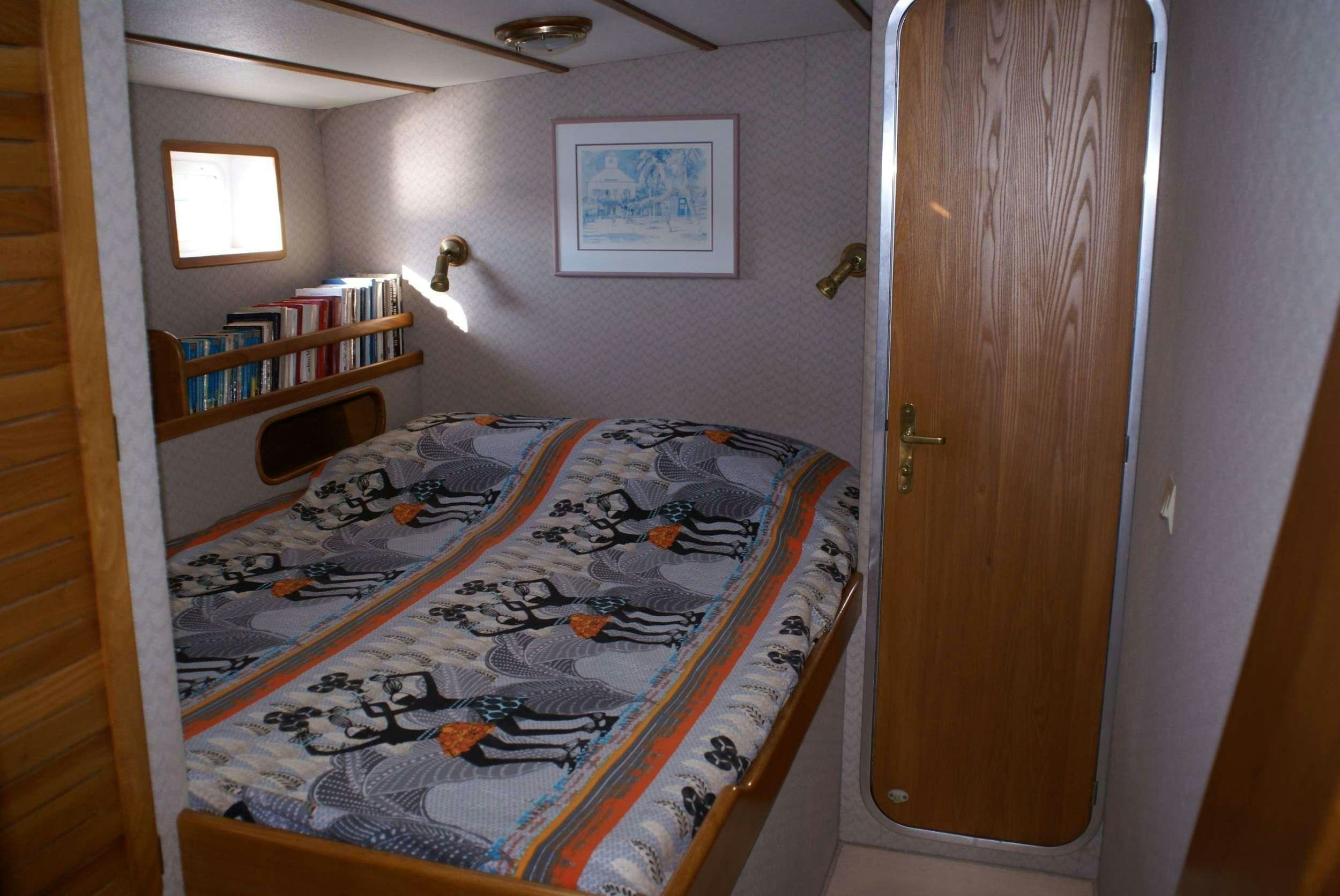 a bedroom with a bed and a bookcase aboard JAIPUR Yacht for Charter