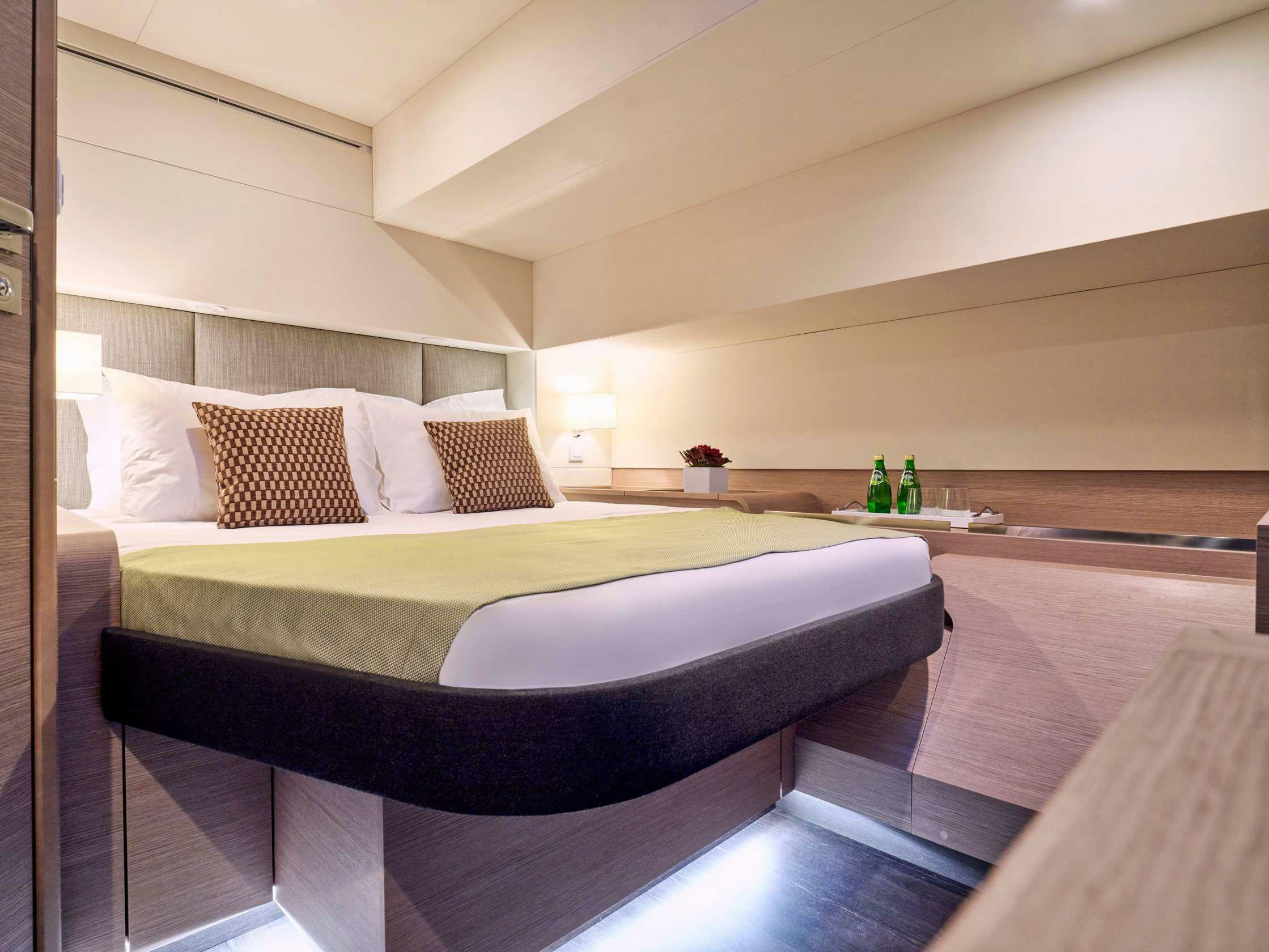 a bed with a white bed spread aboard APHAEA Yacht for Charter