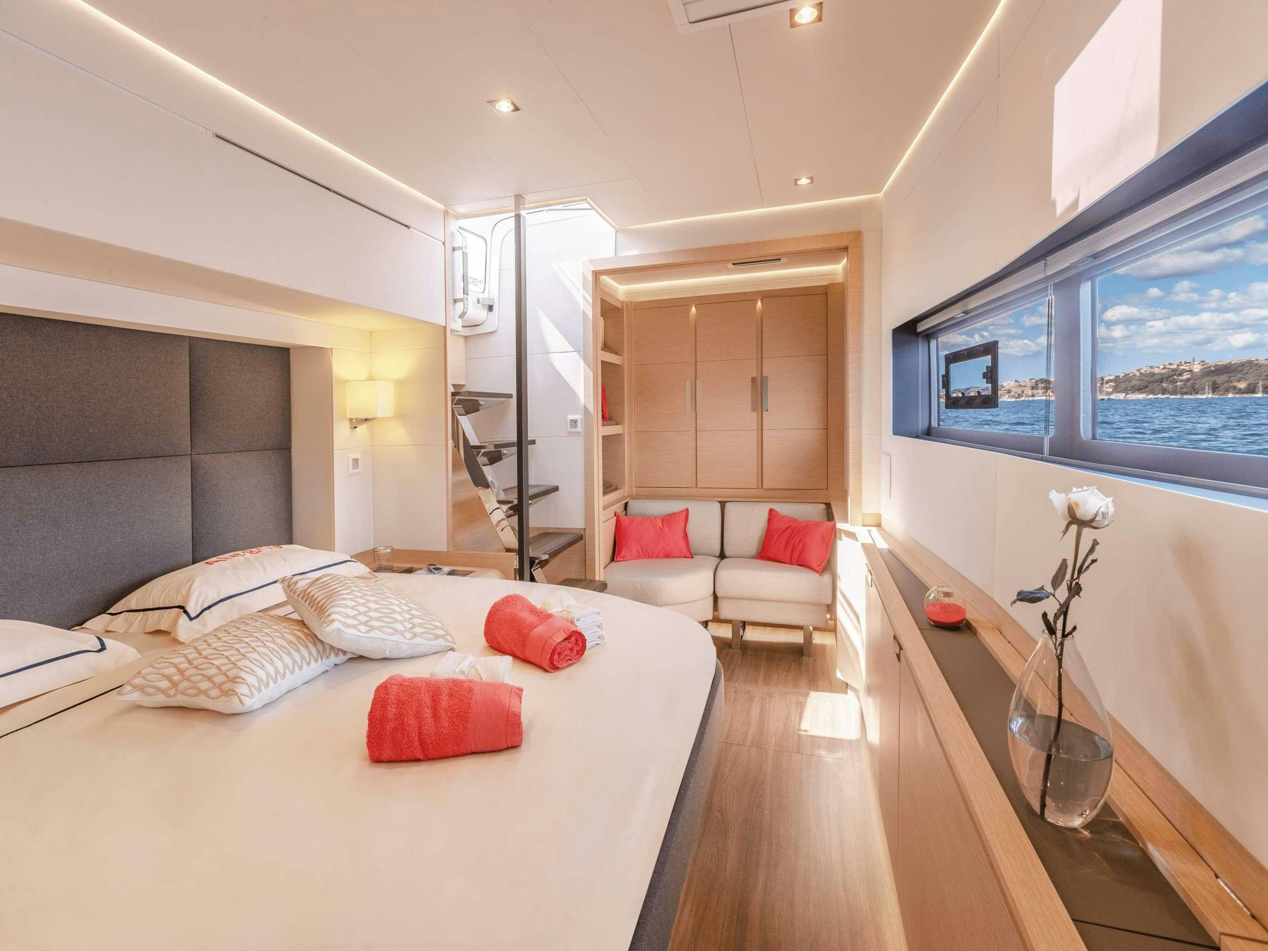 a bedroom with a bed and a table aboard APHAEA Yacht for Charter