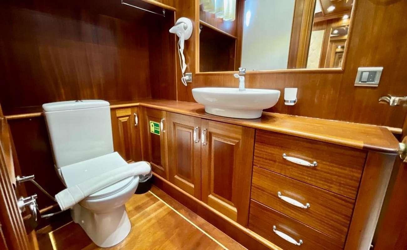 a bathroom with a toilet sink and a mirror aboard QUESTA E VITA Yacht for Charter
