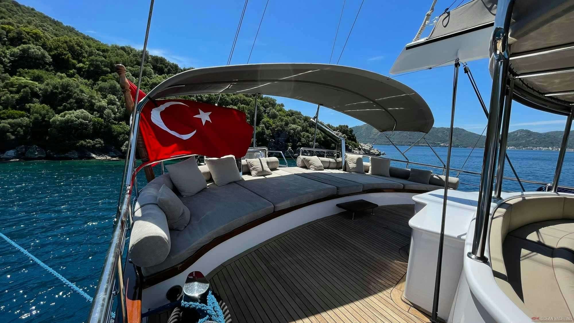 a boat with a flag on the front aboard NEVRA QUEEN Yacht for Charter