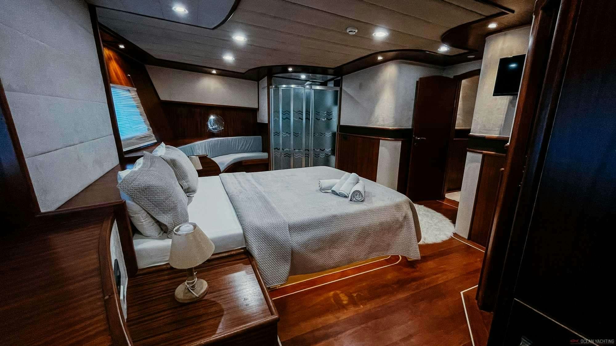 a room with a bed and a chair aboard NEVRA QUEEN Yacht for Charter