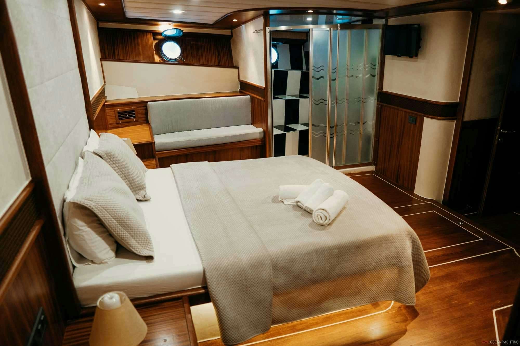 a room with a bed and a desk aboard NEVRA QUEEN Yacht for Charter