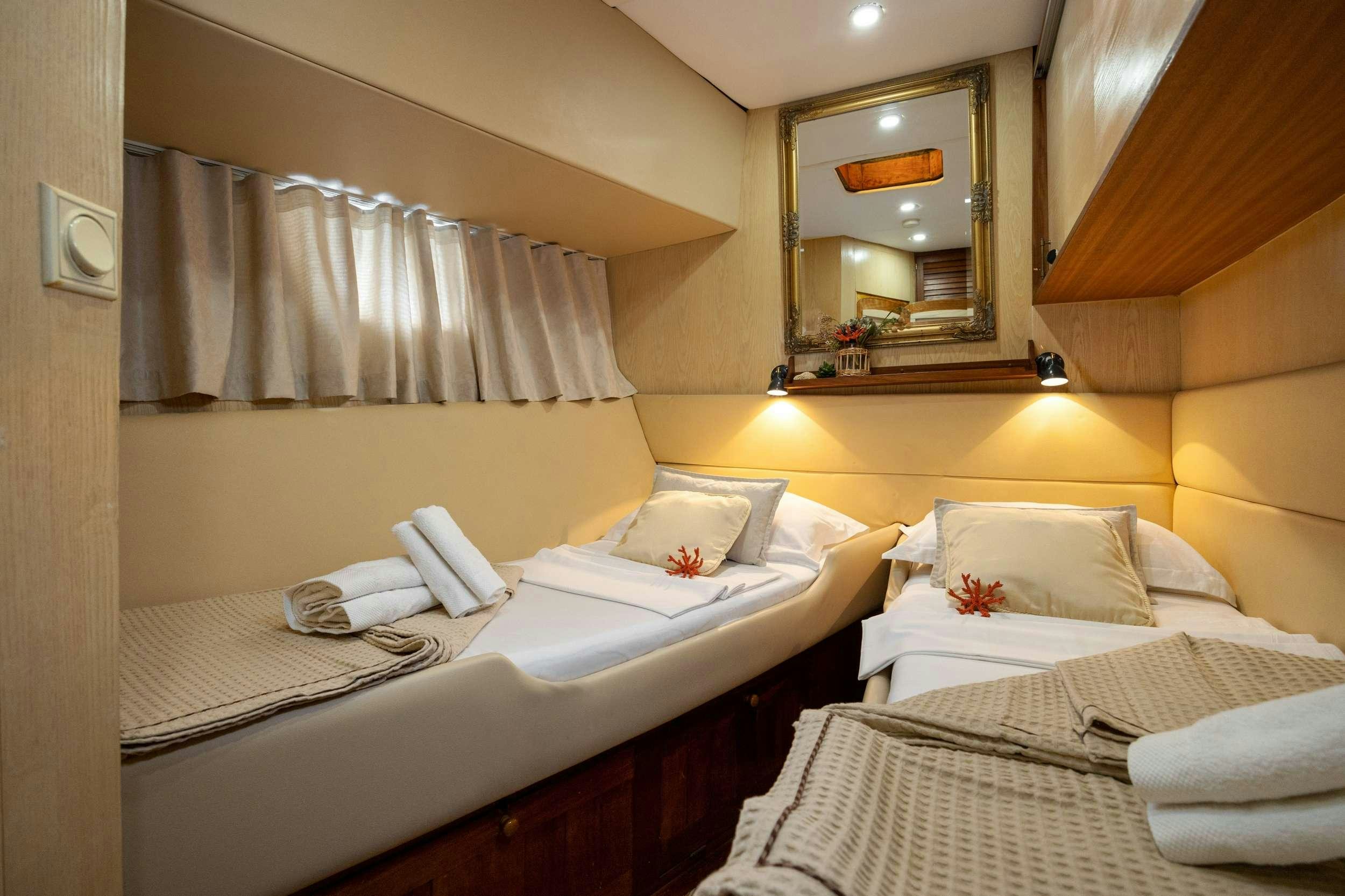 a room with beds and a mirror aboard ABORDA Yacht for Charter