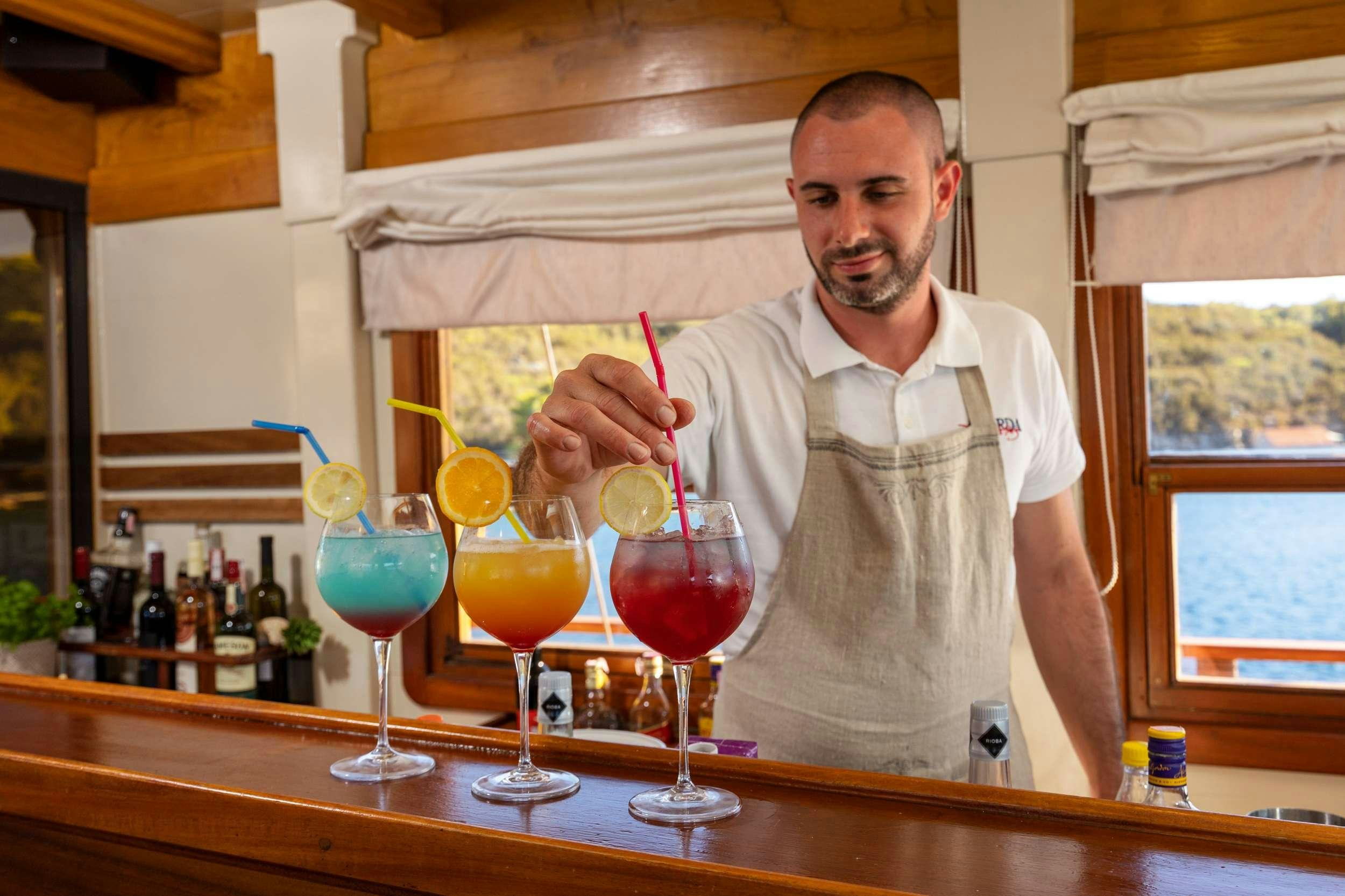 Rosario Miraggio pouring a drink into a glass aboard ABORDA Yacht for Charter