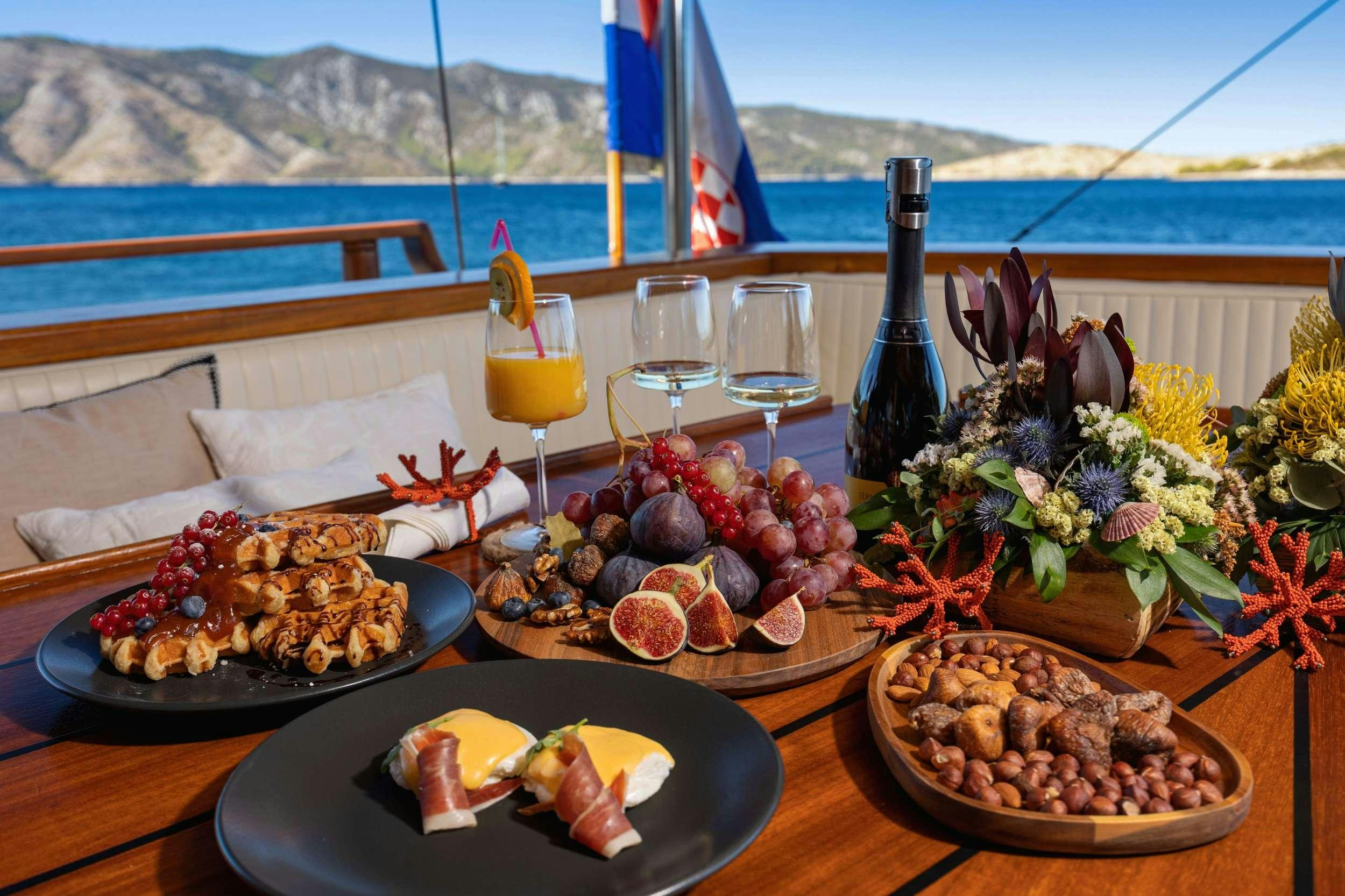 a table with food and drinks on it aboard ABORDA Yacht for Charter