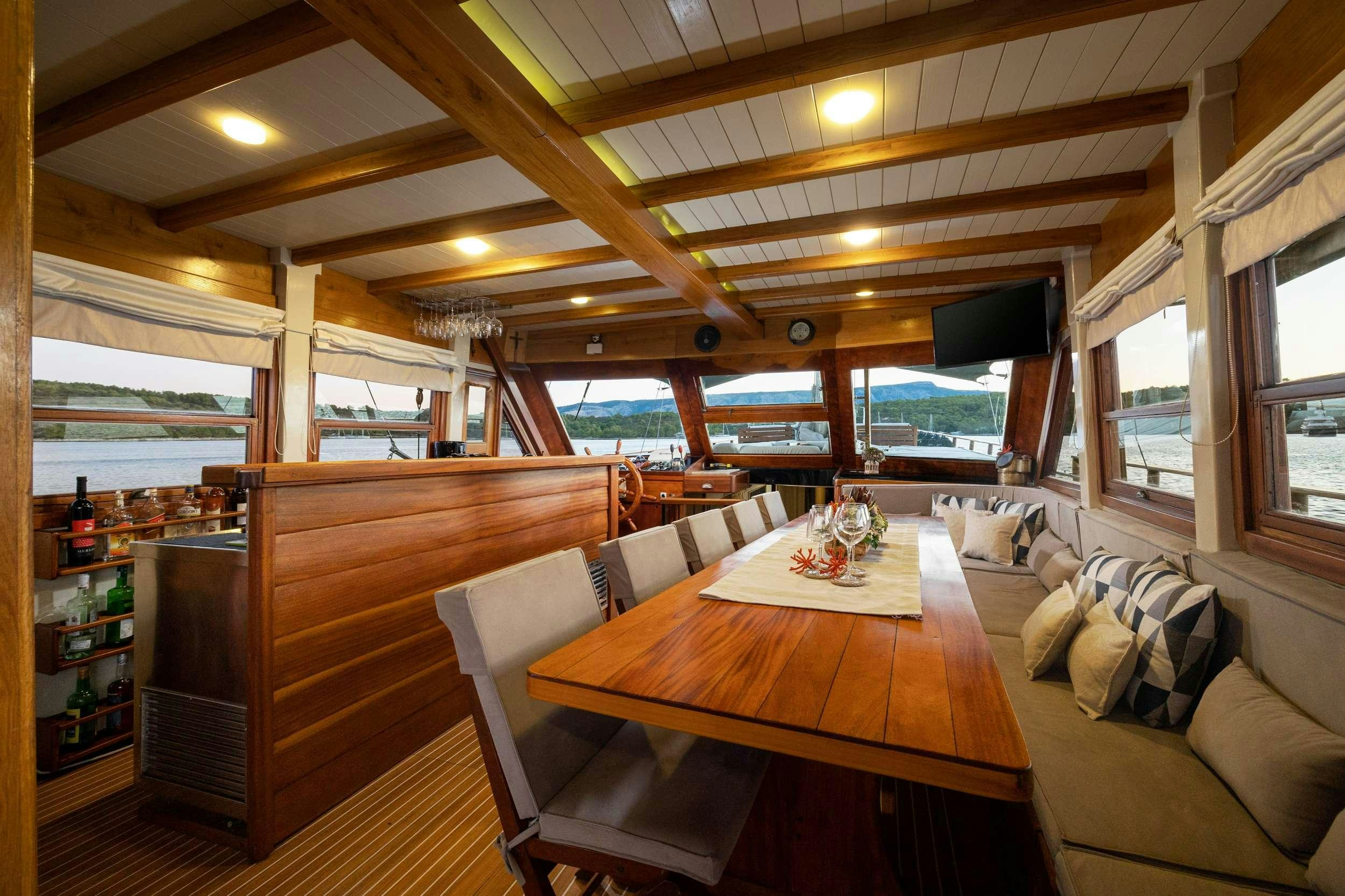 a room with a table and a couch aboard ABORDA Yacht for Charter