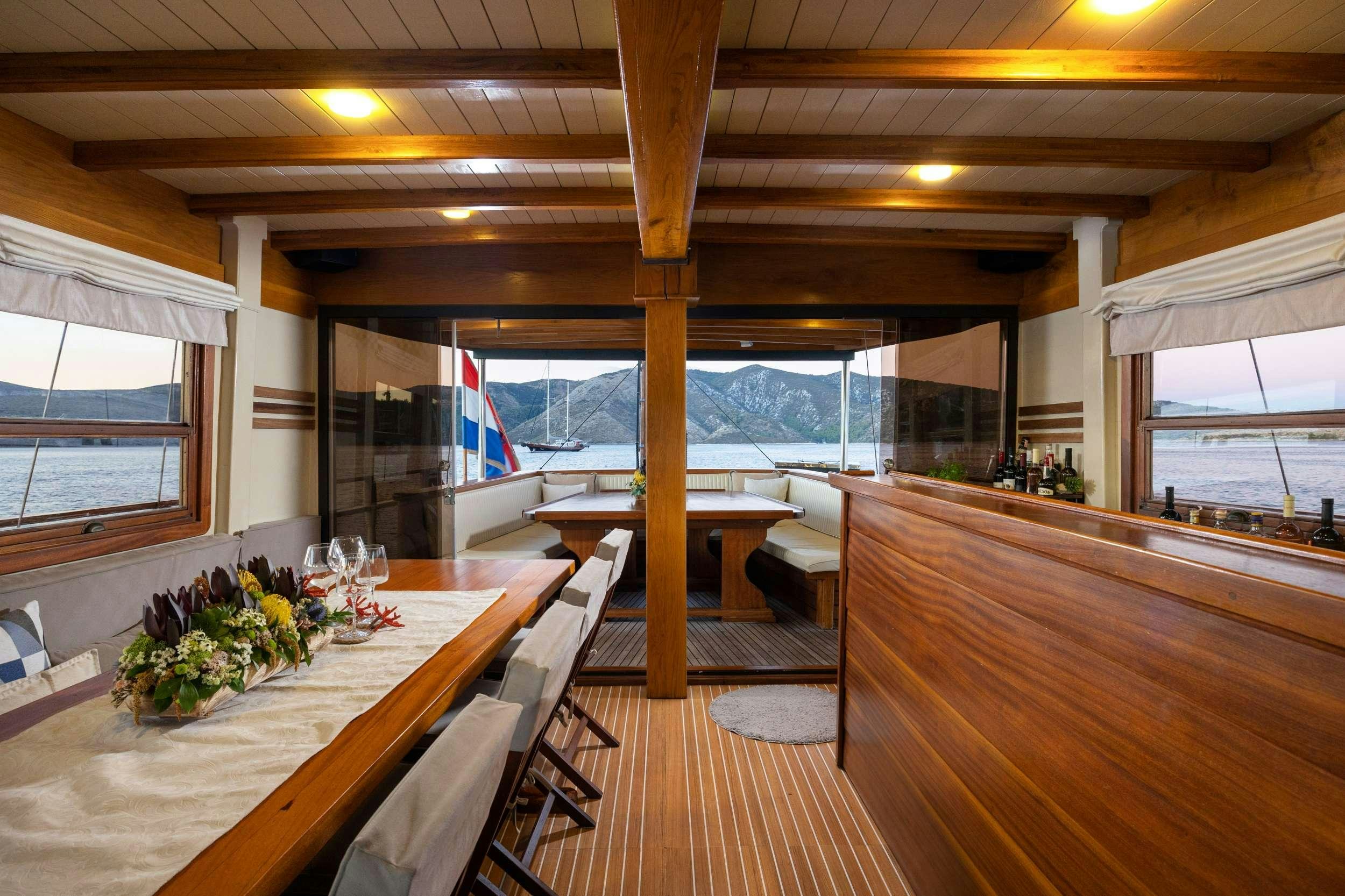 a room with a table and chairs aboard ABORDA Yacht for Charter